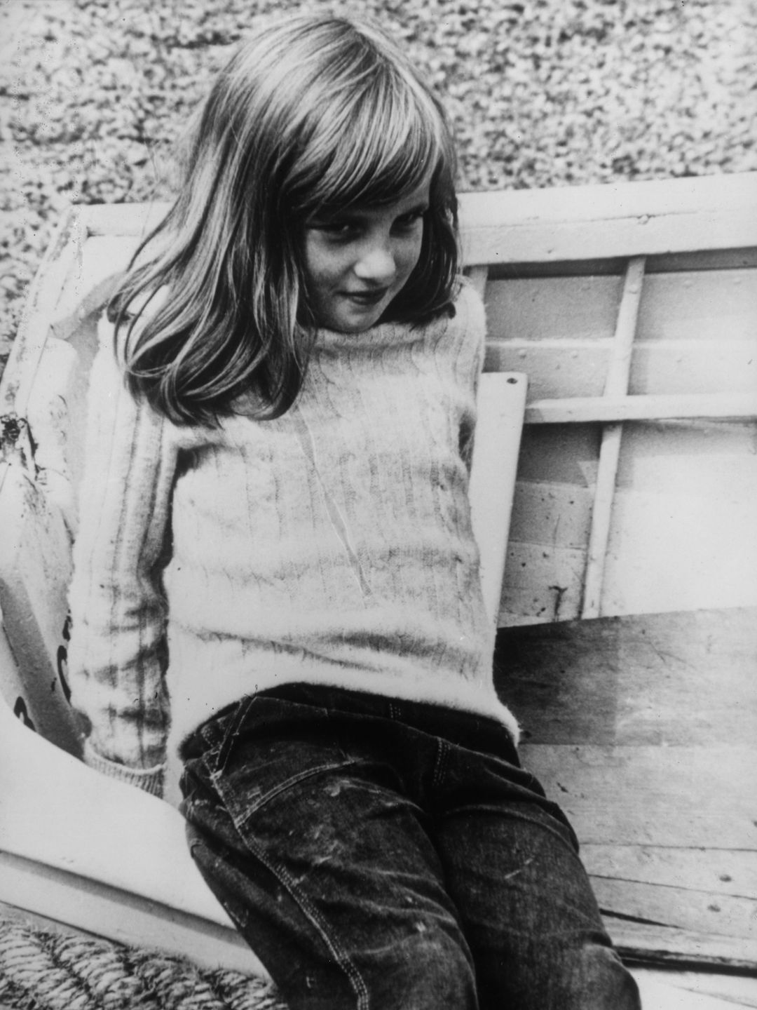 A young Princess Diana on a beach with a small rowboat