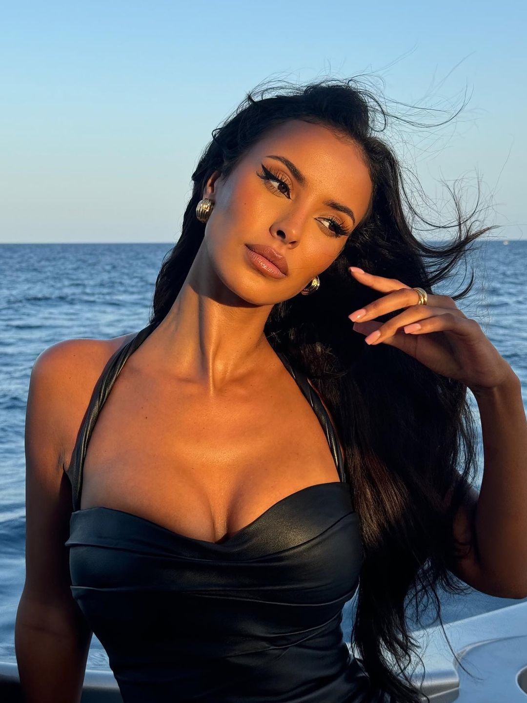 Maya Jama poses in a black leather dress