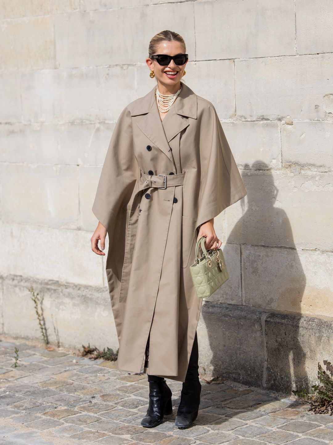 Woman wearing pearl necklace with trench coat 