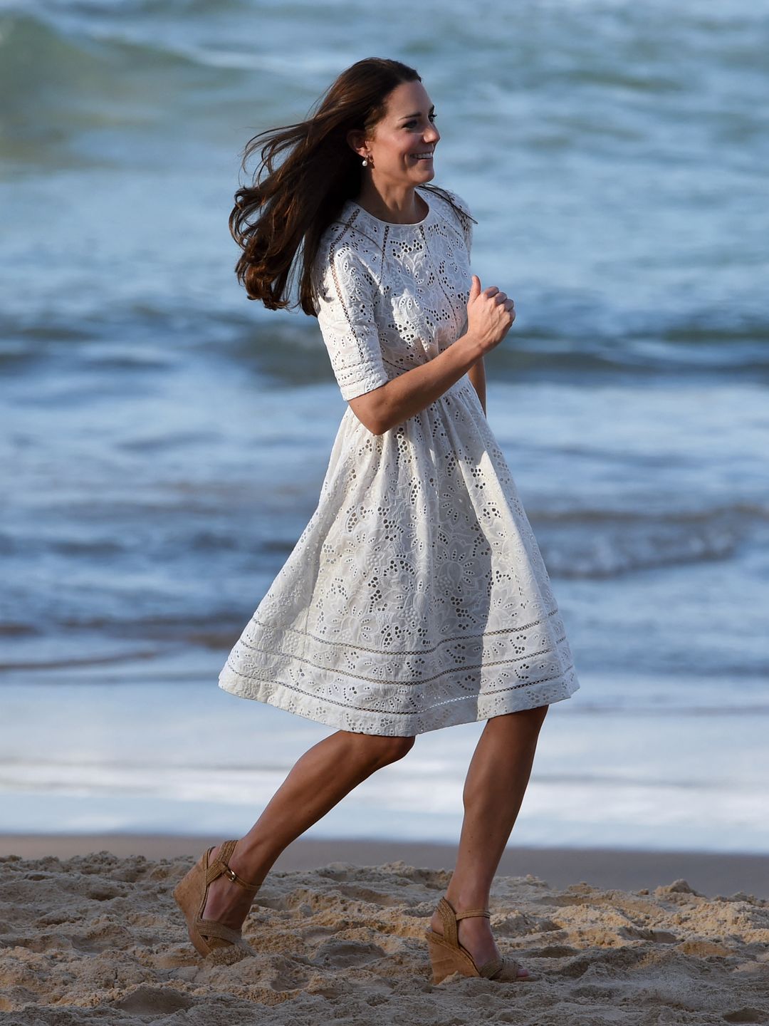 kate running along beach in dress