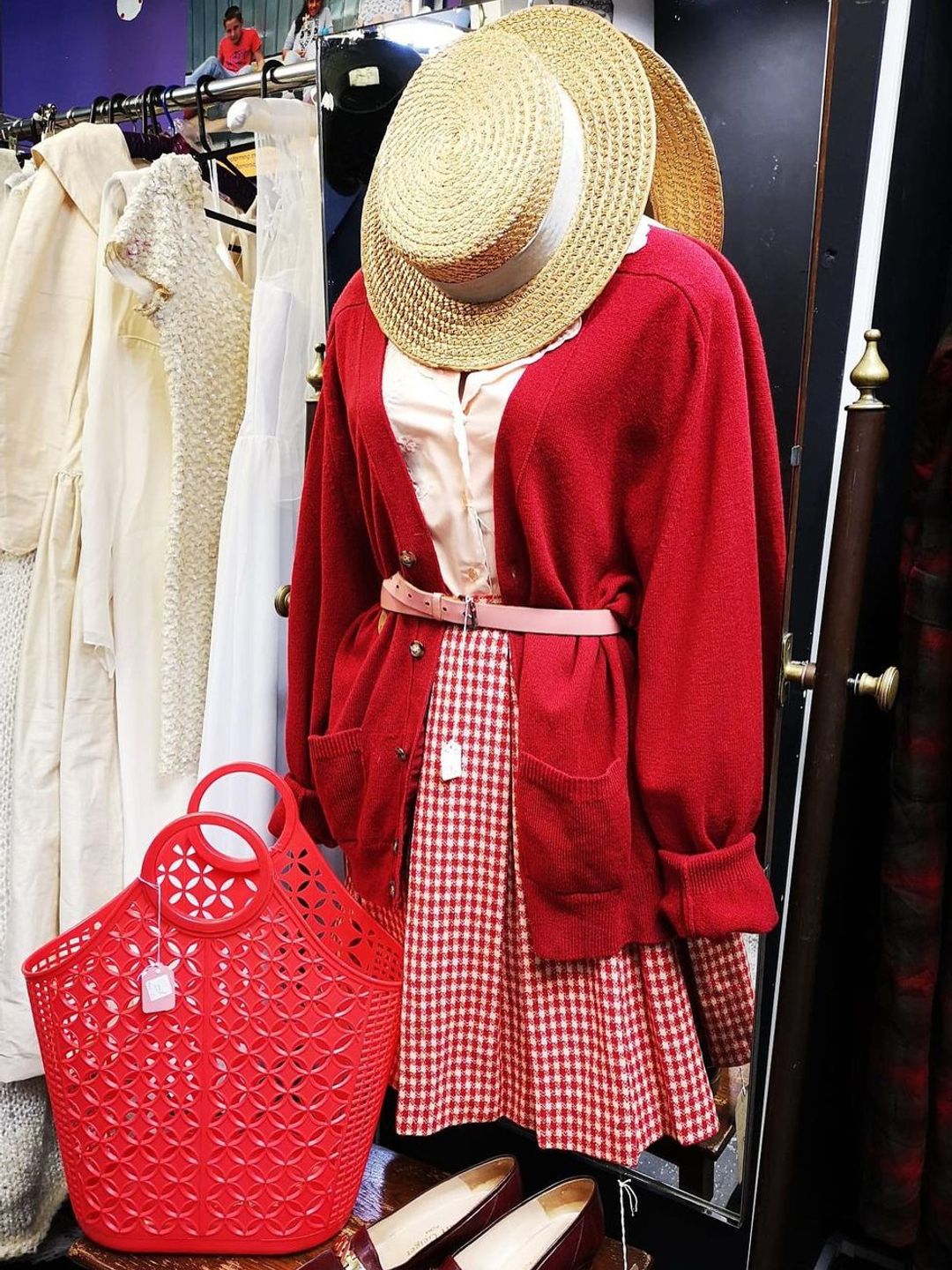Shop mannequin with red cardigan and geometric cut-out bag 
