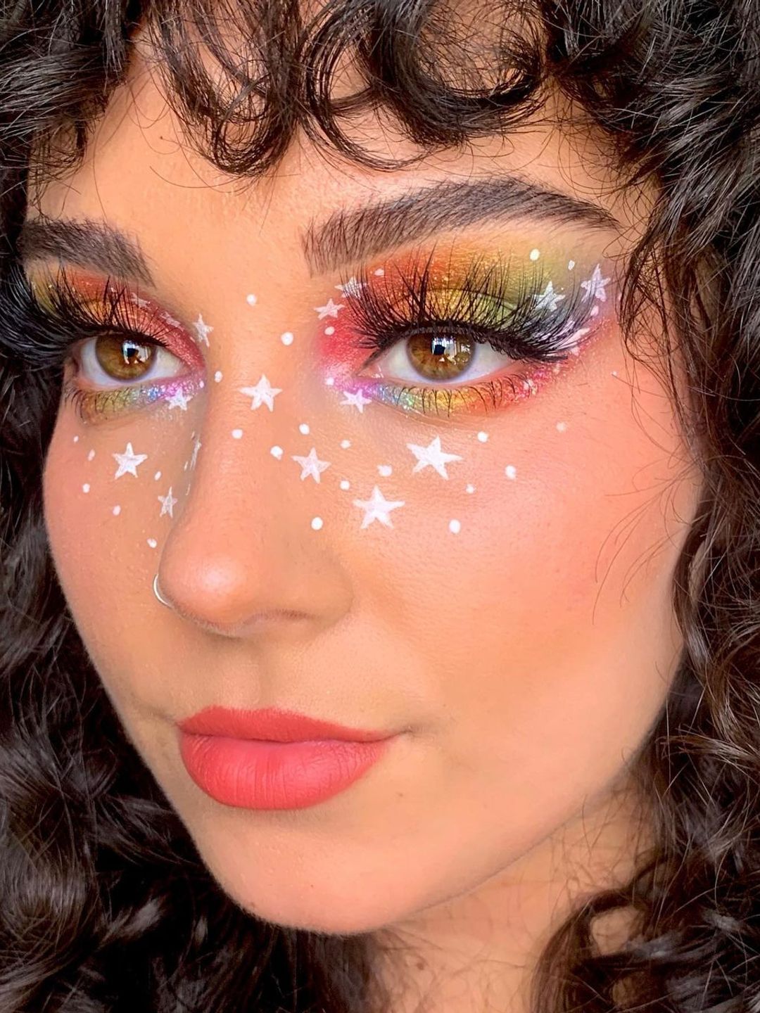 Rainbow eye makeup with white star accents 
