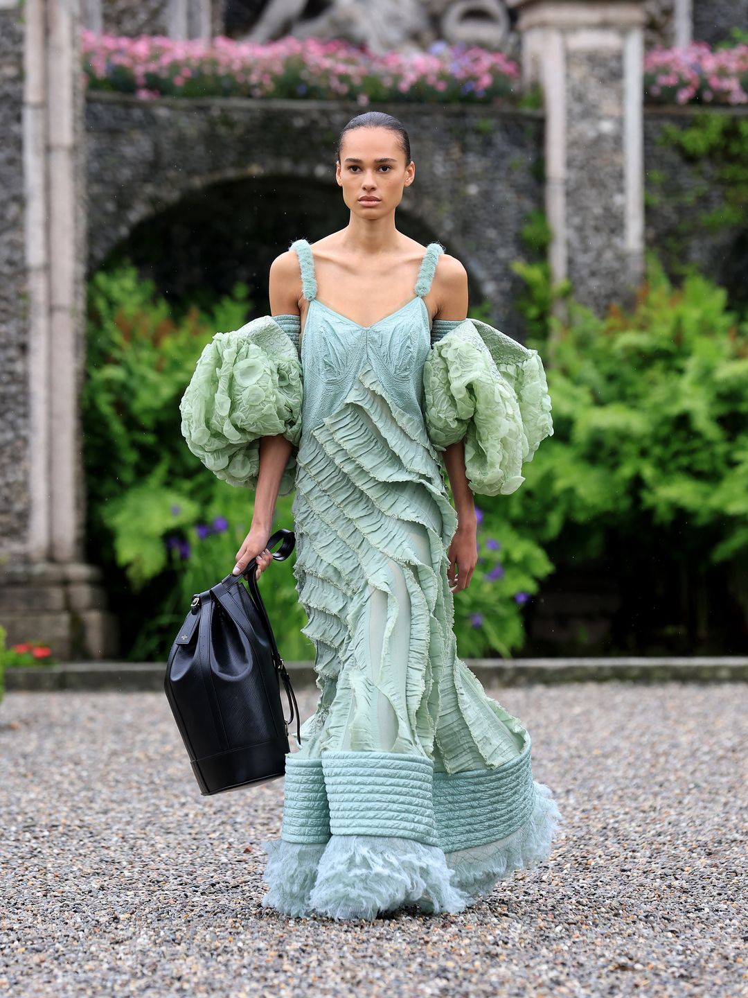 Louis Vuitton model walking the runway in green textured gown with voluminous sleeves 