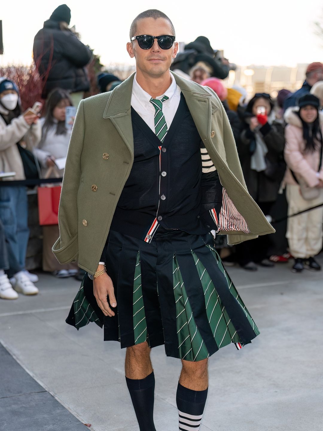 Antoni Porowski is seen arriving to the Thom Browne fashion show in a pleated skirt, blazer and knee-high socks