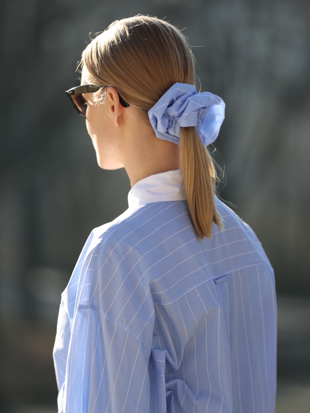 Spotted on the streets of Munich, this oversized scrunchie is working overtime to make this fit more than just a plain collared shirt ensemble