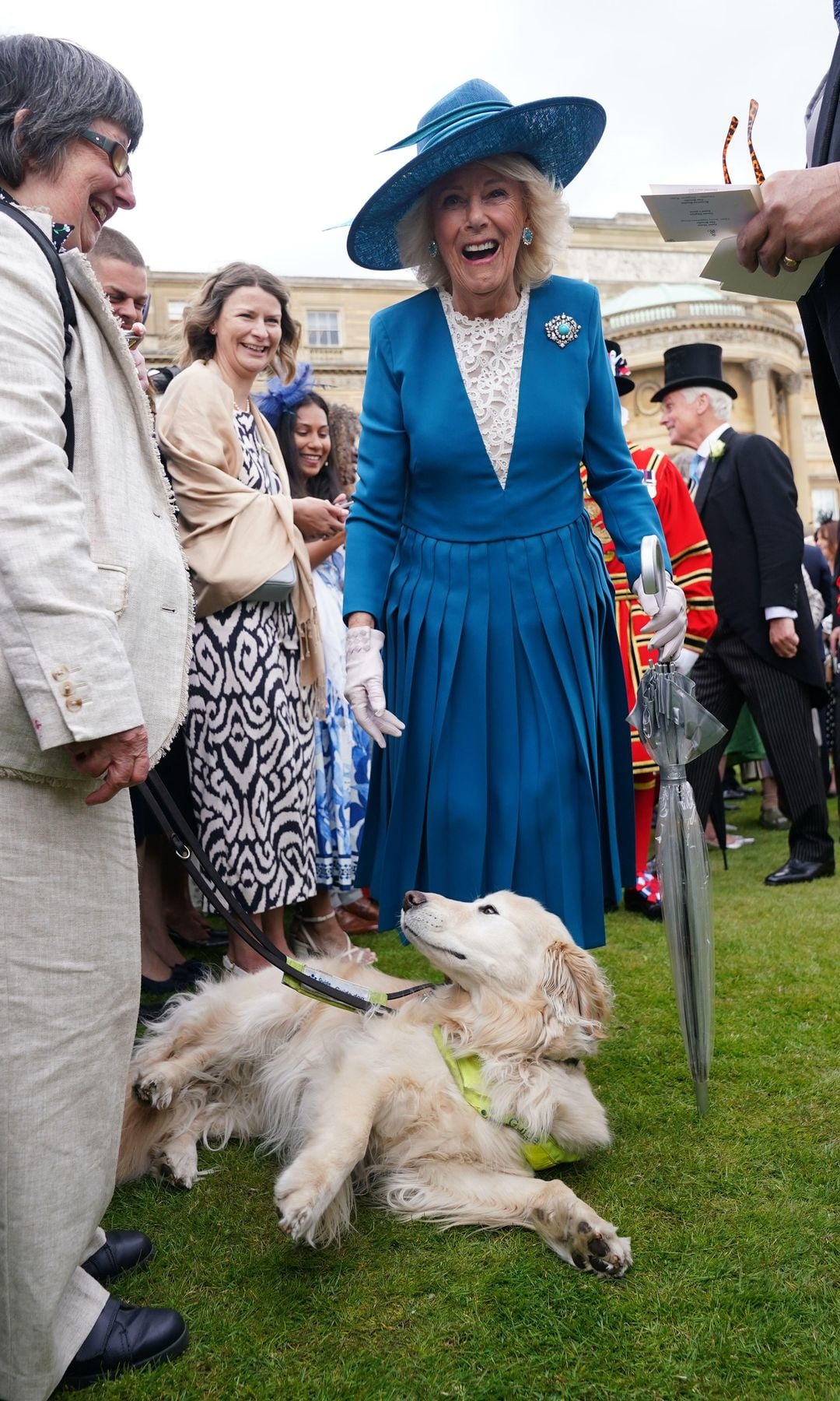 Queen Camilla laughing by a guide dog