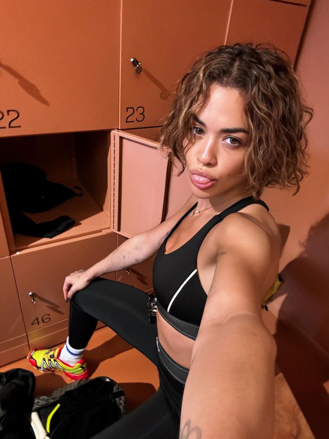 Rita Ora wears bright yellow and red sneakers and workout gear