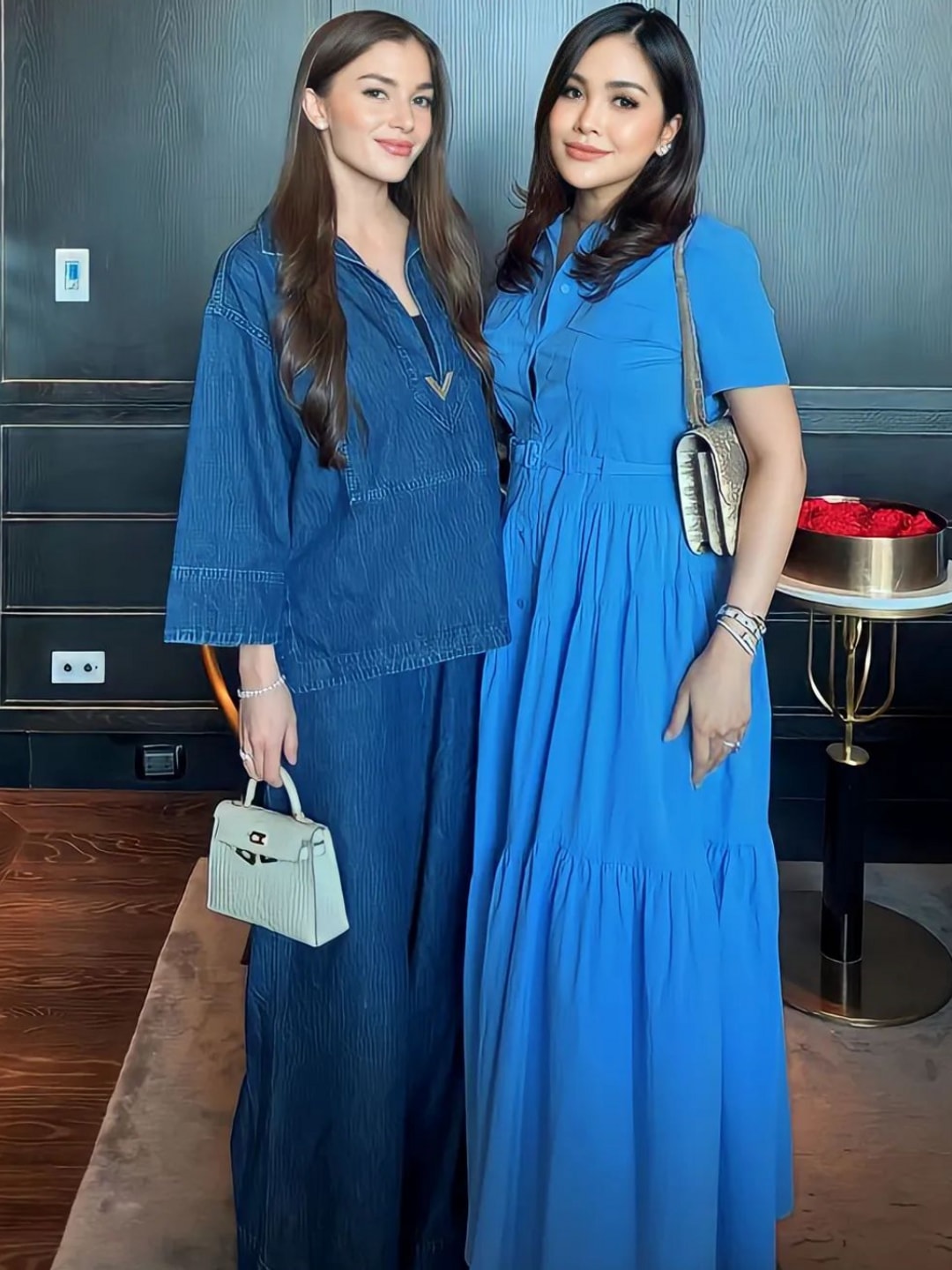 Princess Anisha poses with a friend in a double denim look with a mini white bag 