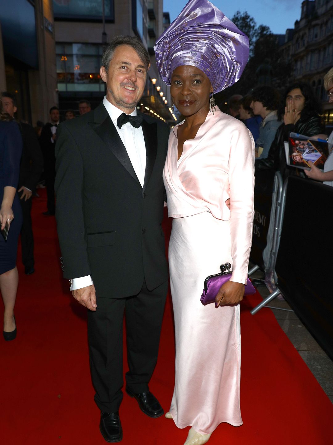 Adam Smethurst in a suit with Rakie Ayola in a pink dress and purple headdress at the British Academy Cymru Awards,