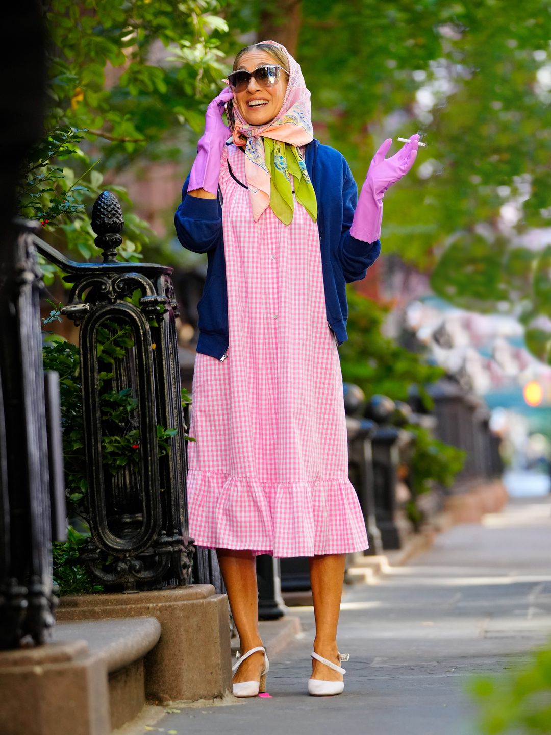 Carrie Bradshaw smoking in a pink gingham dress with a headscarf 