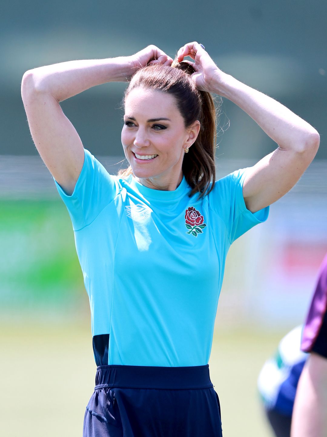 princess kate adjusting hair in blue top