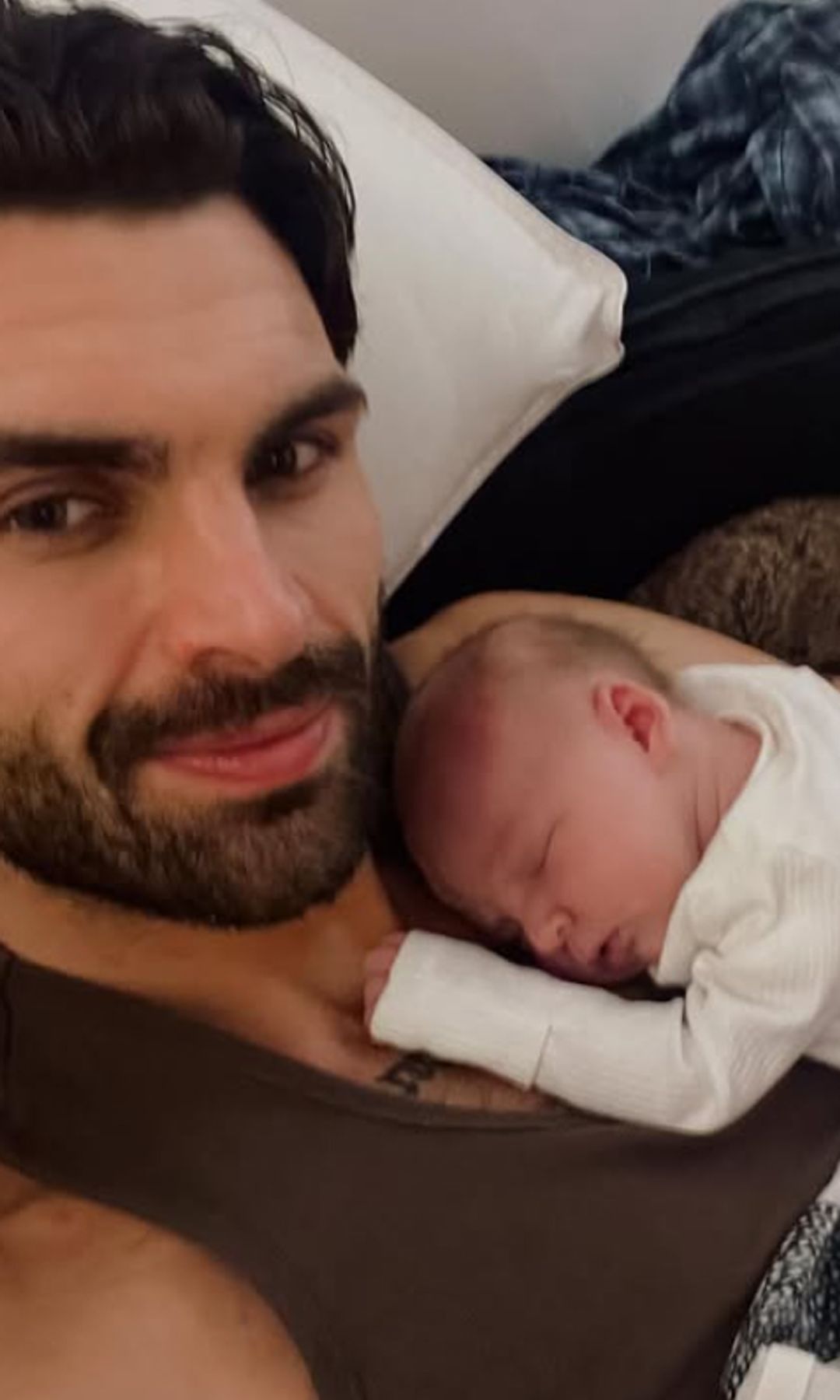 Adam Collard cuddled up with a baby boy