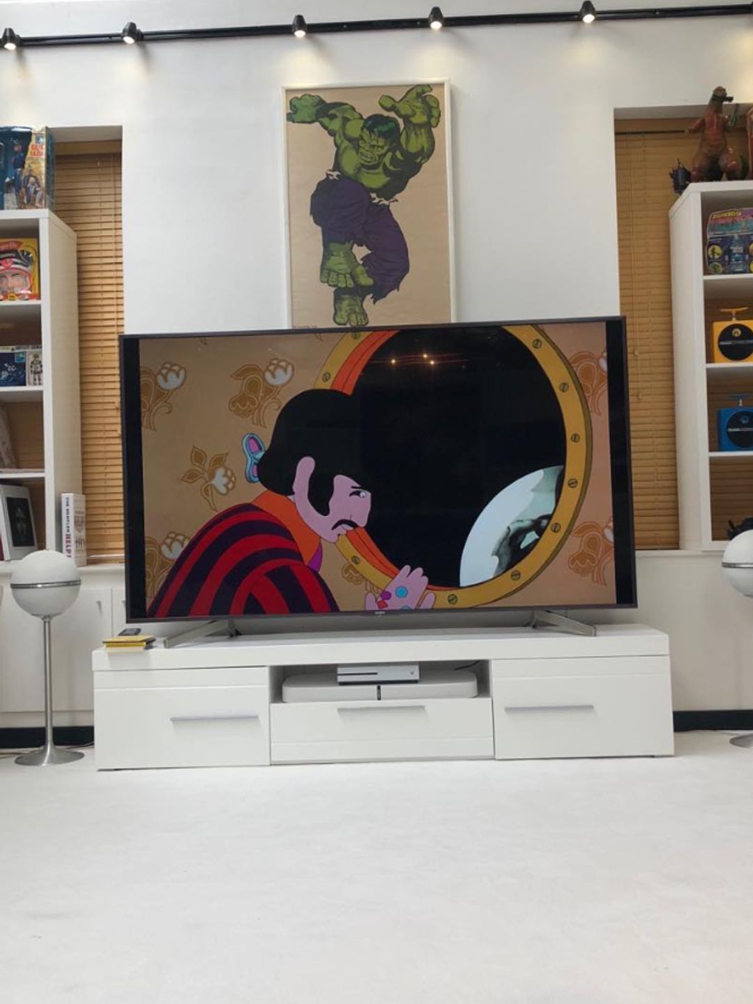 A TV playing Yellow Submarine with as Hulk poster behind it