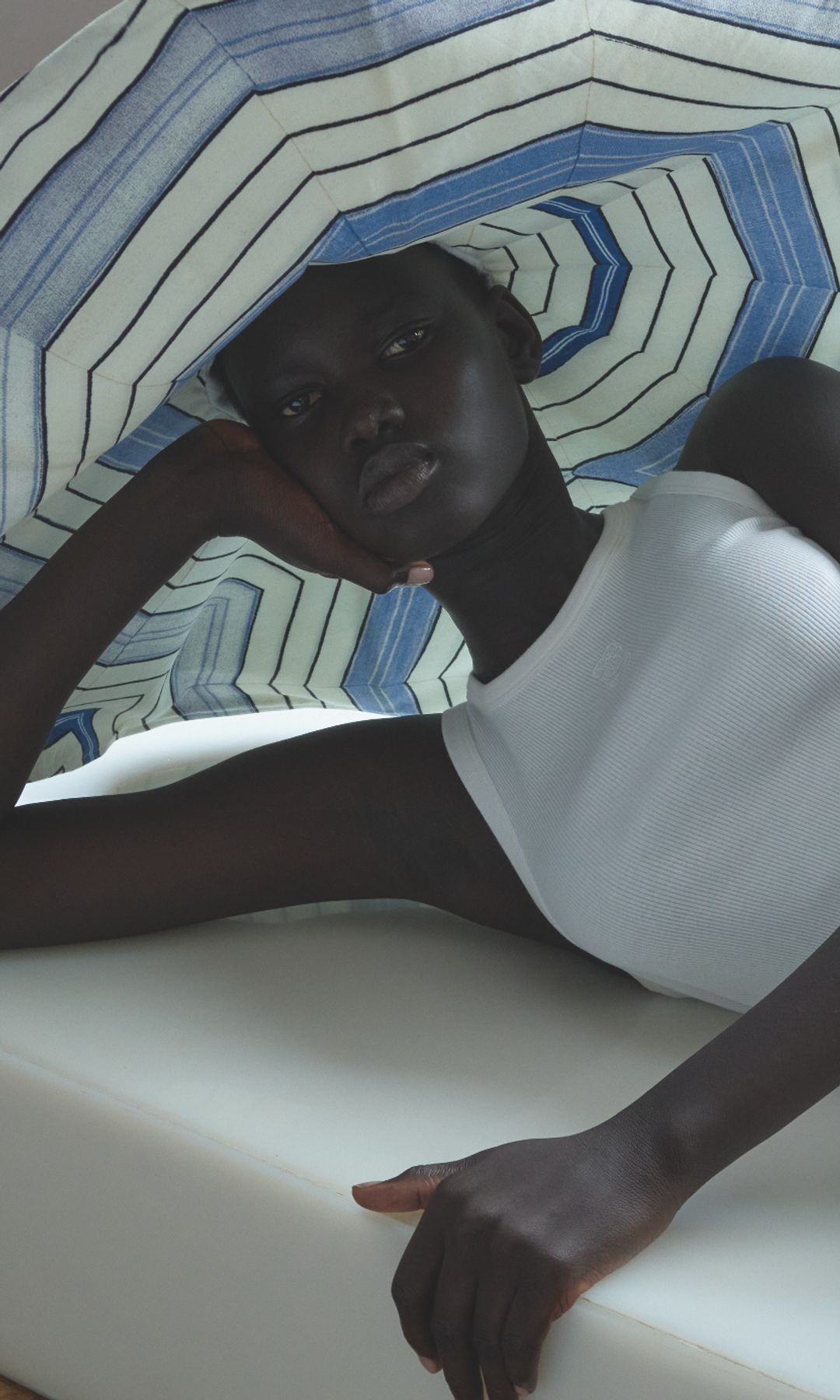 A model poses in a stripey hat and plain vest for the new Sandro SS25 capsule