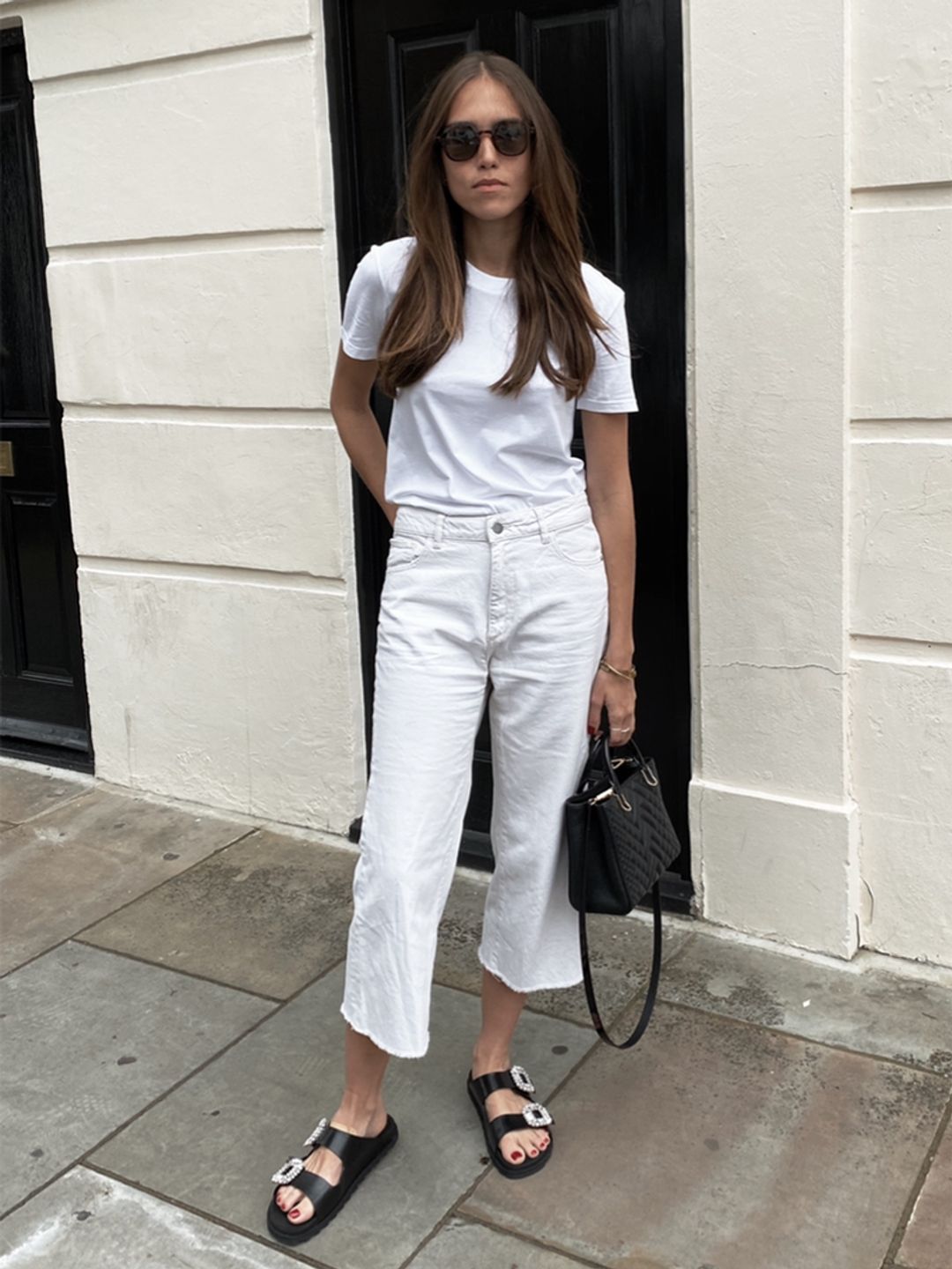 Natalie Salmon wearing a white T-shirt and cream jeans 