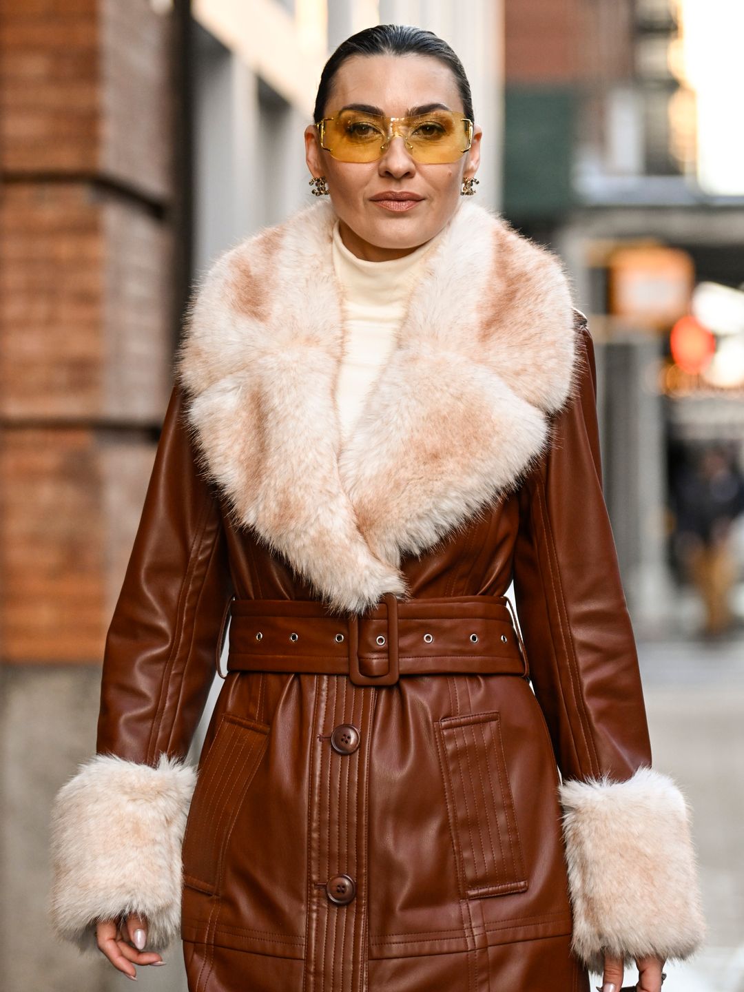 Yana Echko is seen wearing Stand Studio coat, ByFar bag, Chanel earrings and Le Specs sunglasses outside the Michael Kors show