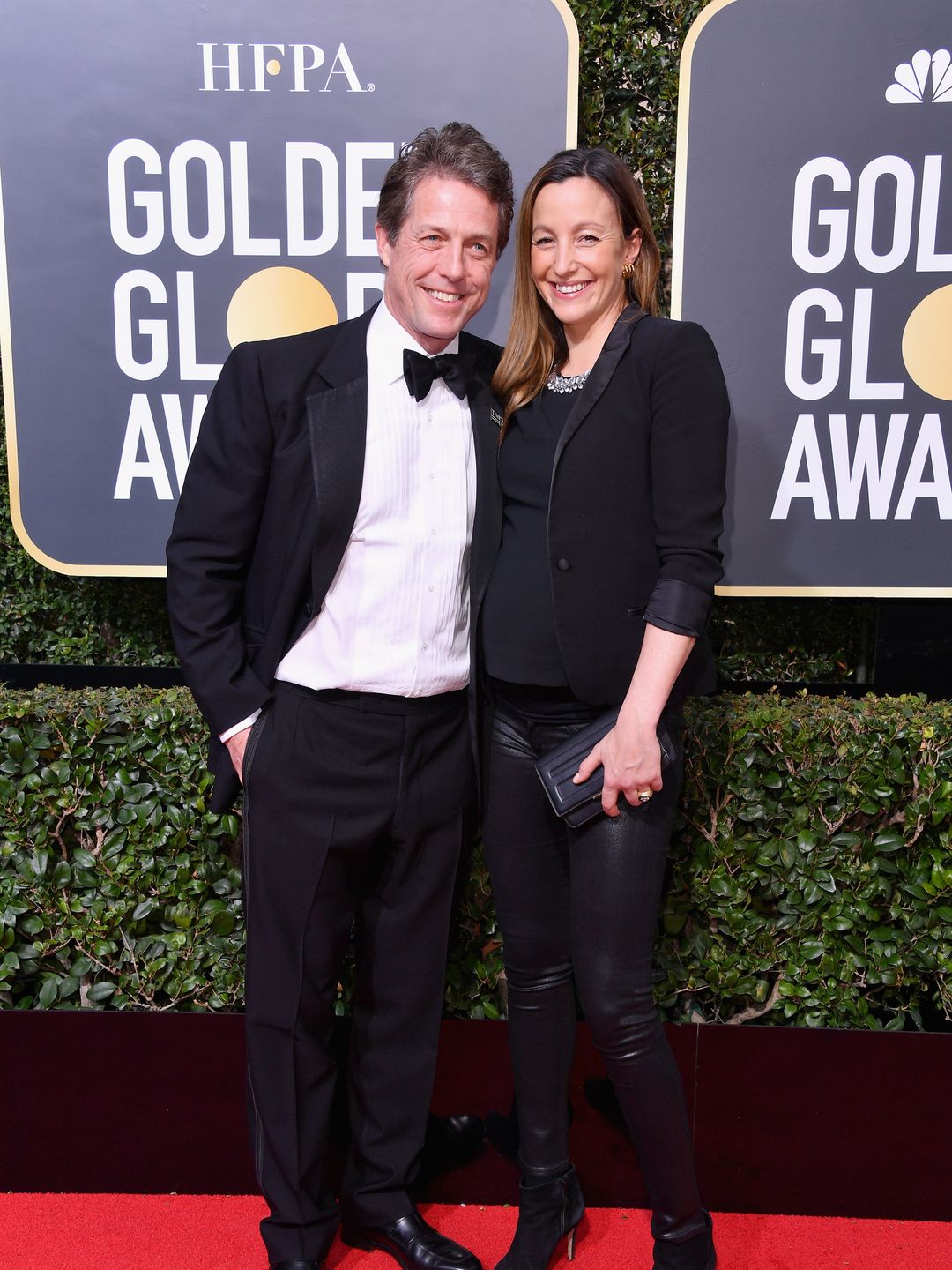 hugh grant on red carpet with pregnant wife