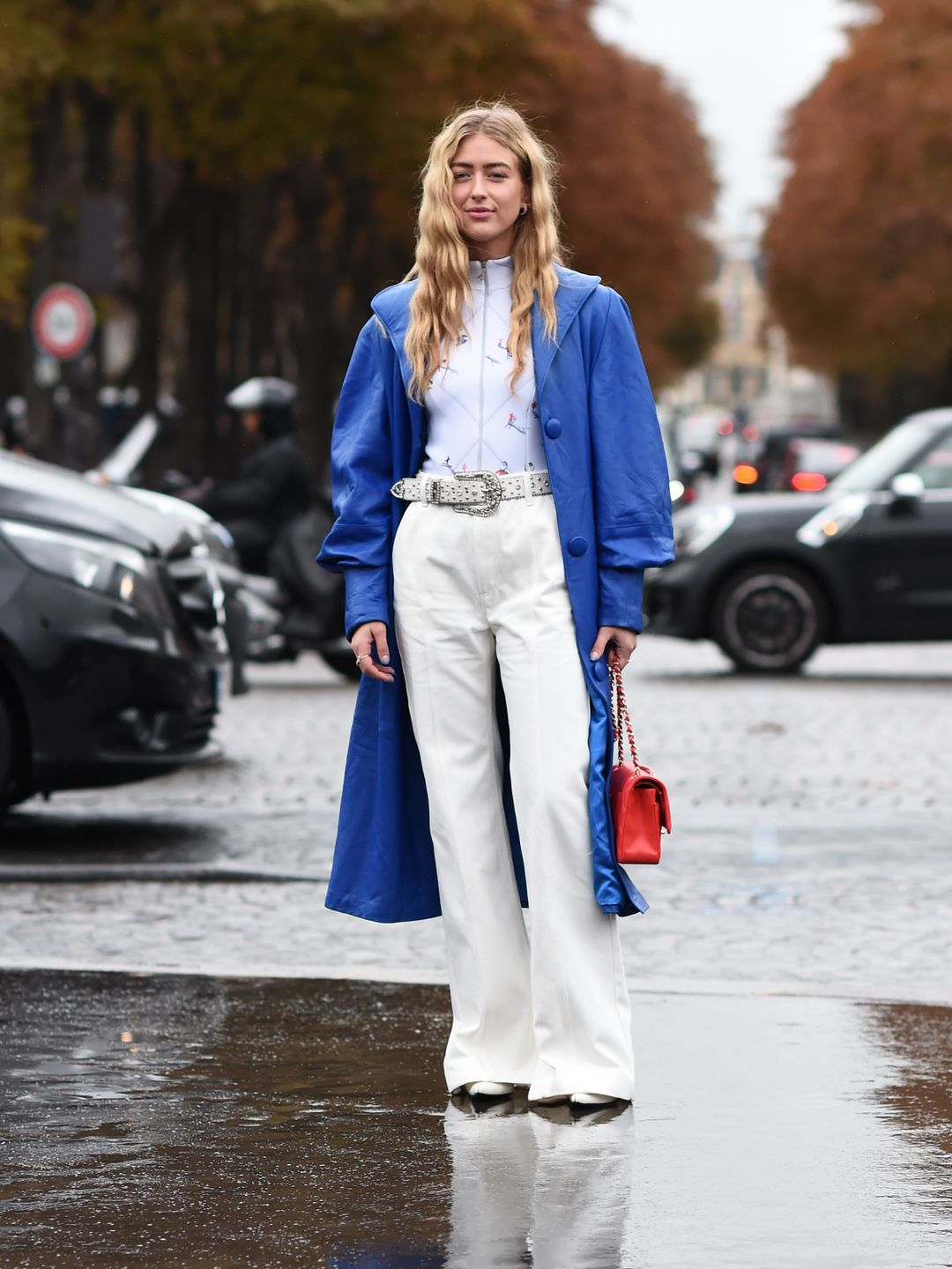 Fashion week guest wearing white jeans with a blue coat 