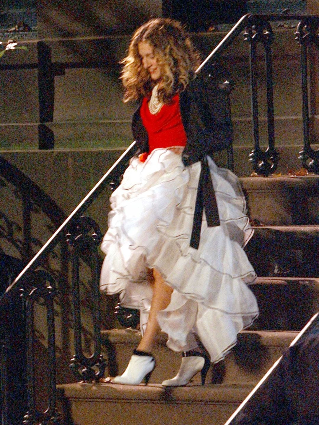 Carrie Bradshaw walking down steps wearing a white tiered skirt 