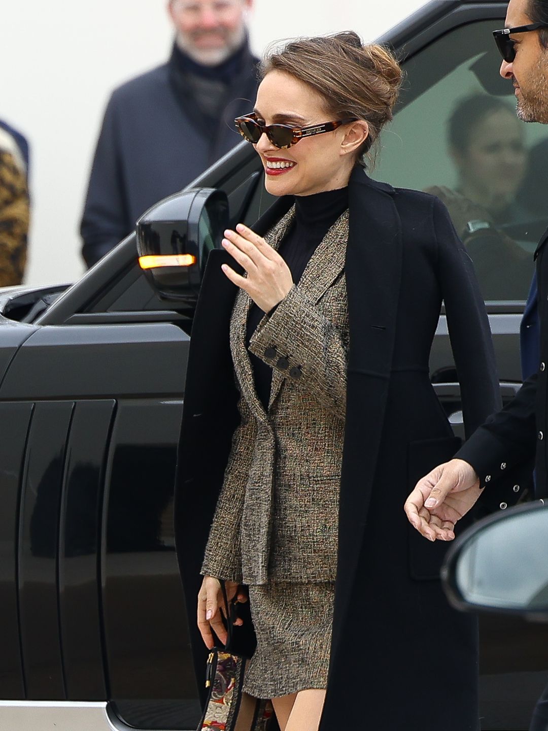 Actress Natalie Portman attends the Christian Dior in a tweed mini skirt and blazer, black coat and sunglasses