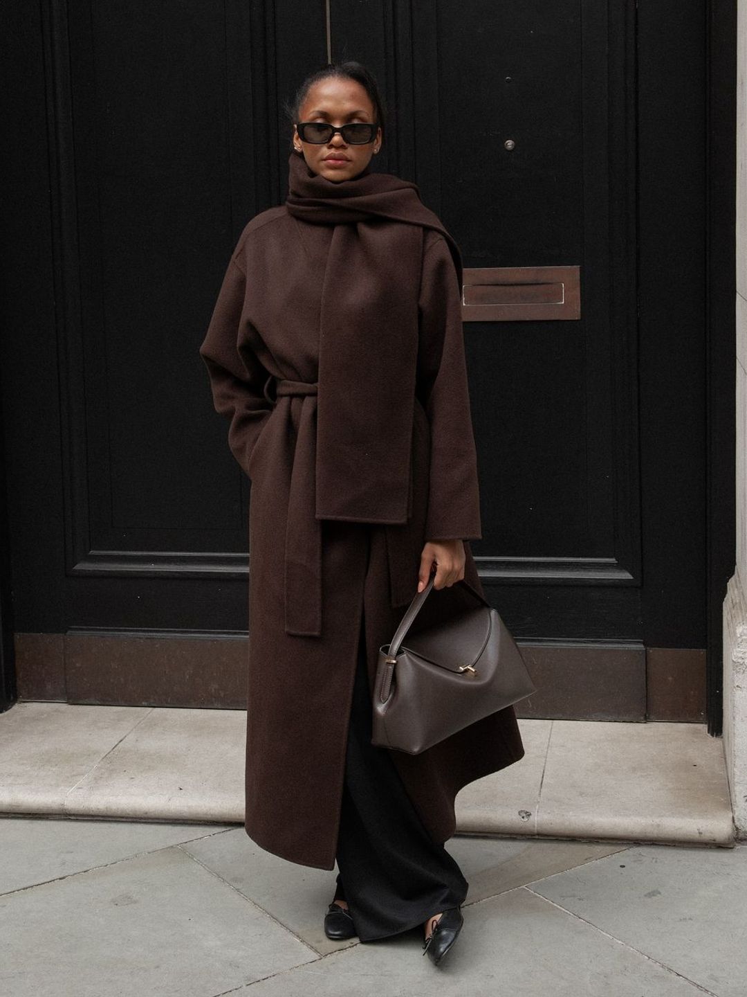 model with brown coat and bag