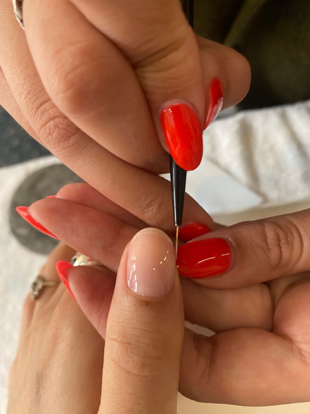 Nail with white tip being applied 