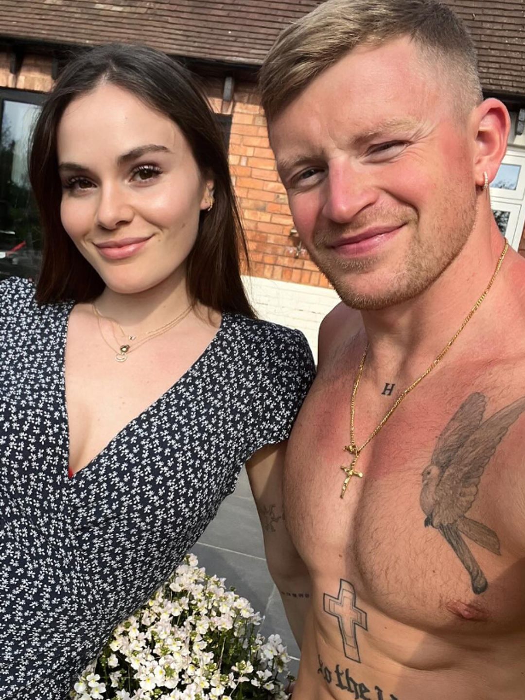 Holly Ramsay in a black dress and a shirtless Adam Peaty in a garden