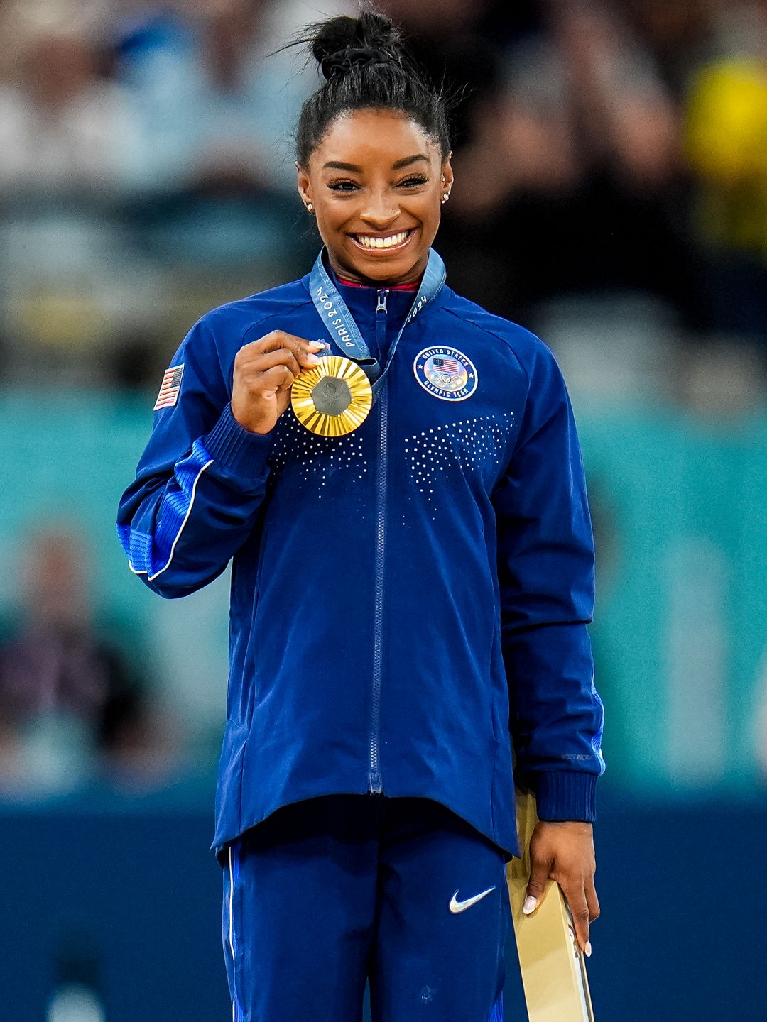 Simone Biles on the podium in blue outfit