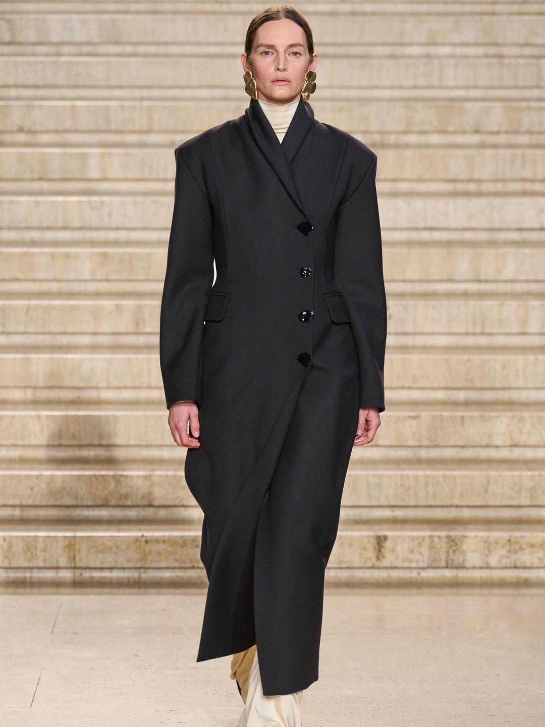 Model wearing black long hourglass shape coat 