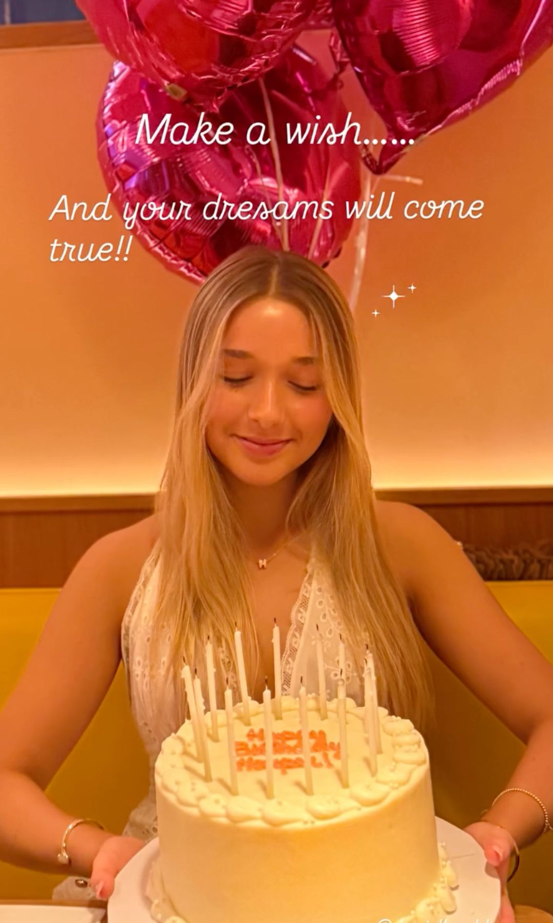 Harper seven wearing a broderie anglaise dress and holding her birthday cake 