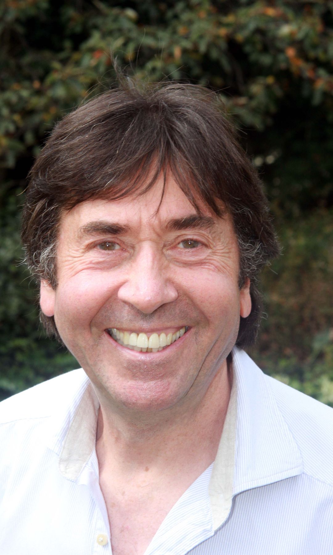 David Janson smiling in front of a forest background