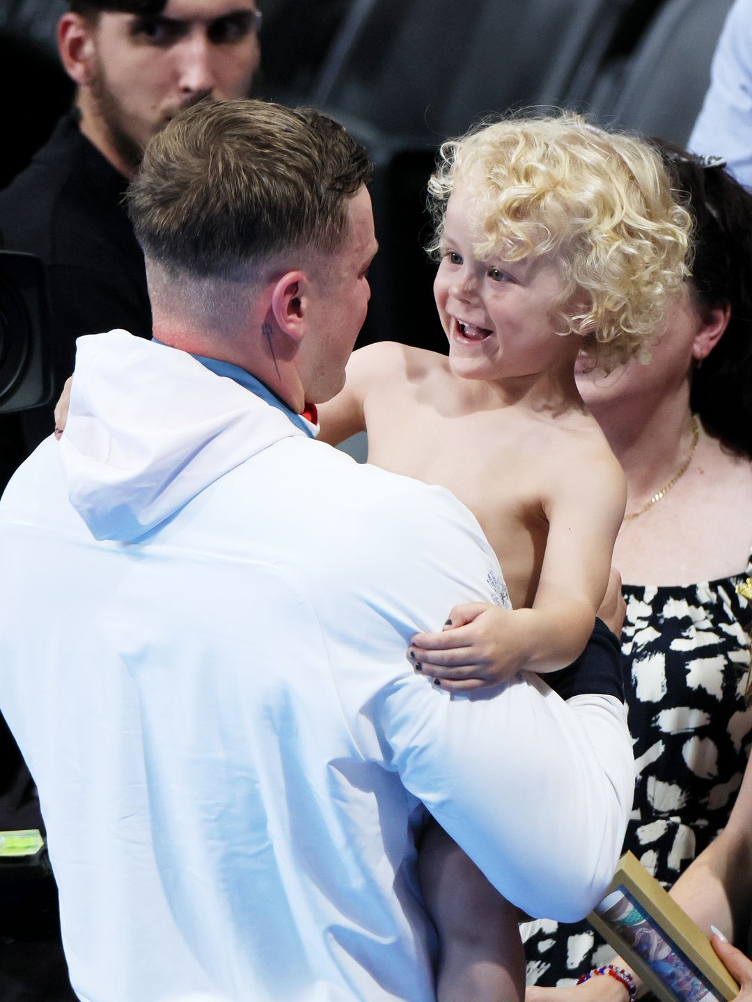 Adam Peaty holding his son