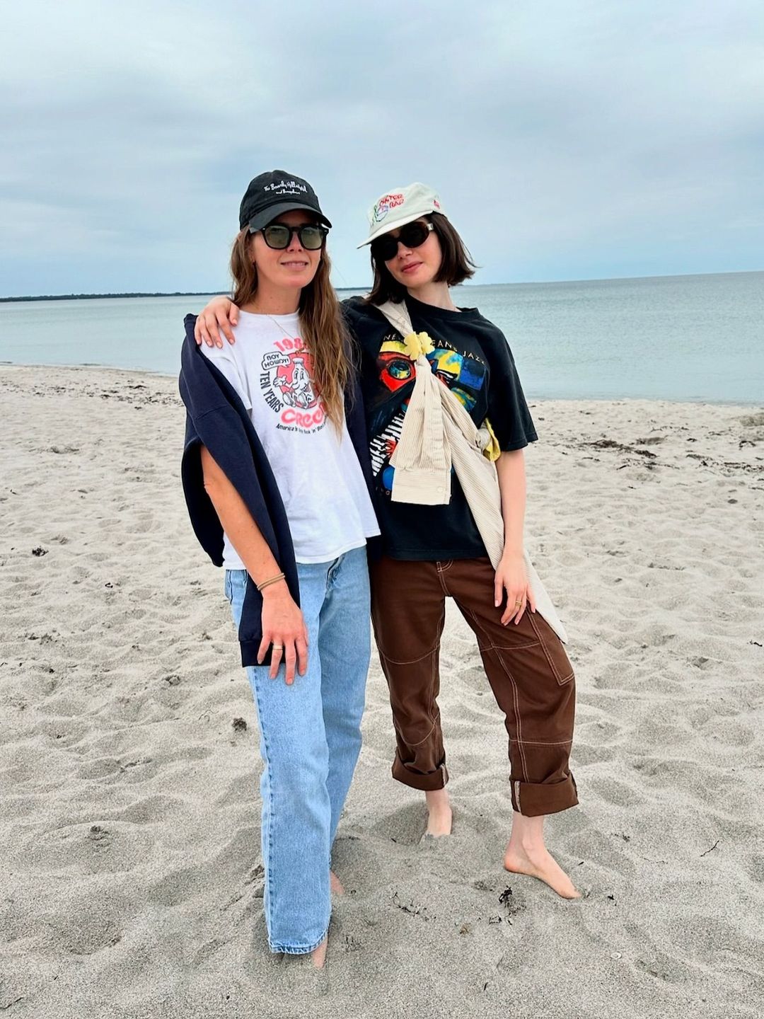 Lily Collins poses on a beach with her friend