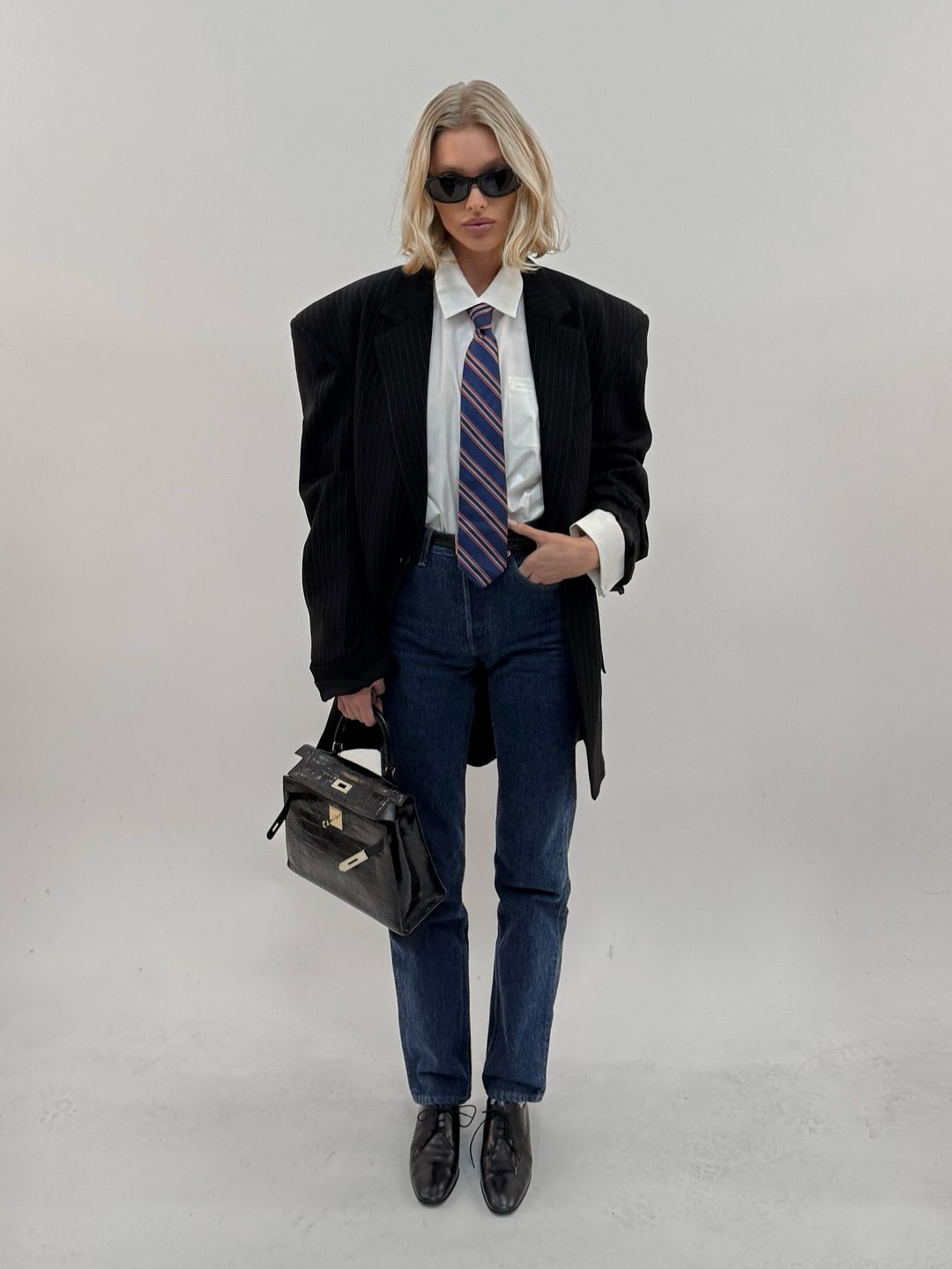 Elsa Hosk poses in a blazer, jeans necktie and shirt on her Instagram