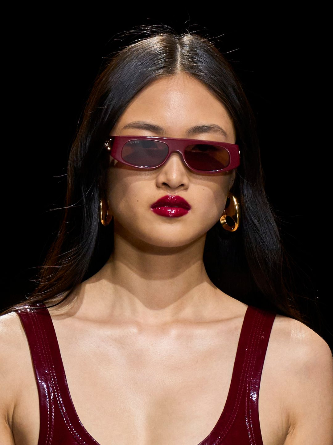 Model with red sunglasses and glossy lips at Gucci SS24 