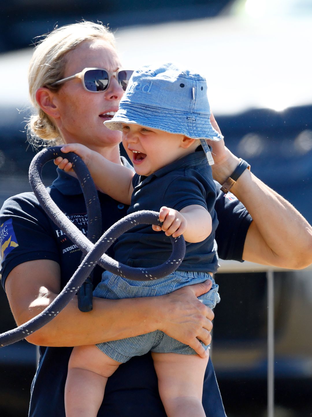 mother adjusting son's hat at horse show 