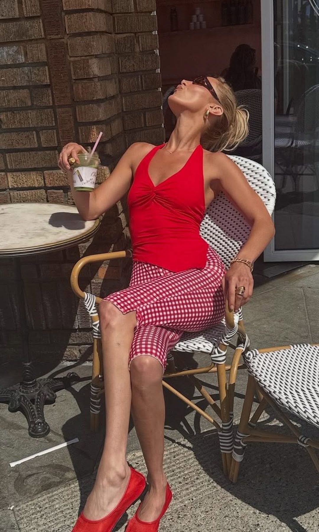 Bella Hadid wears gingham capri pants and a red halter neck top 
