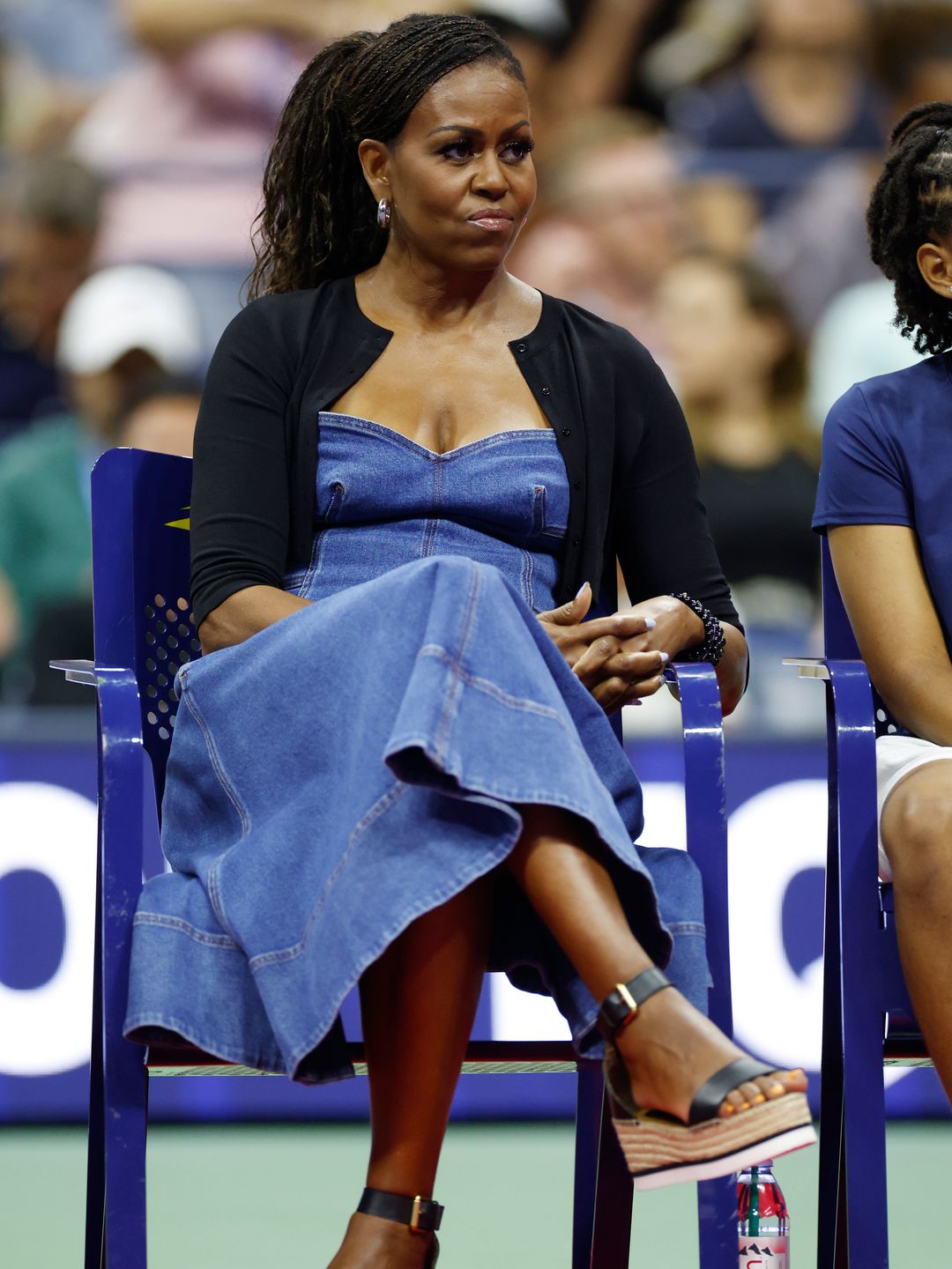 Michelle Obama seated, wearing a denim maxi dress