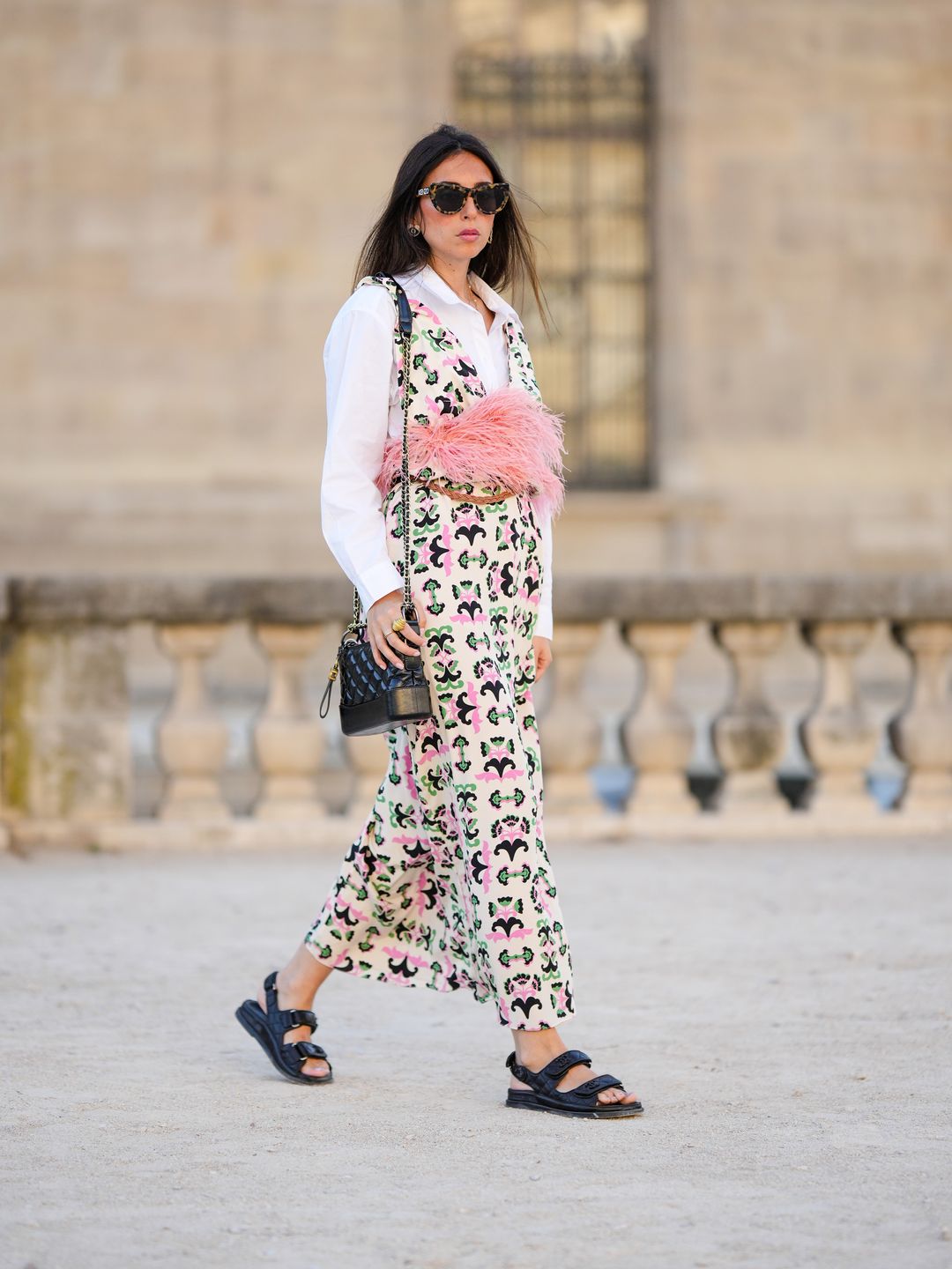 Gabriella Berdugo wears printed dress with pink feather waist detail over white shirt 