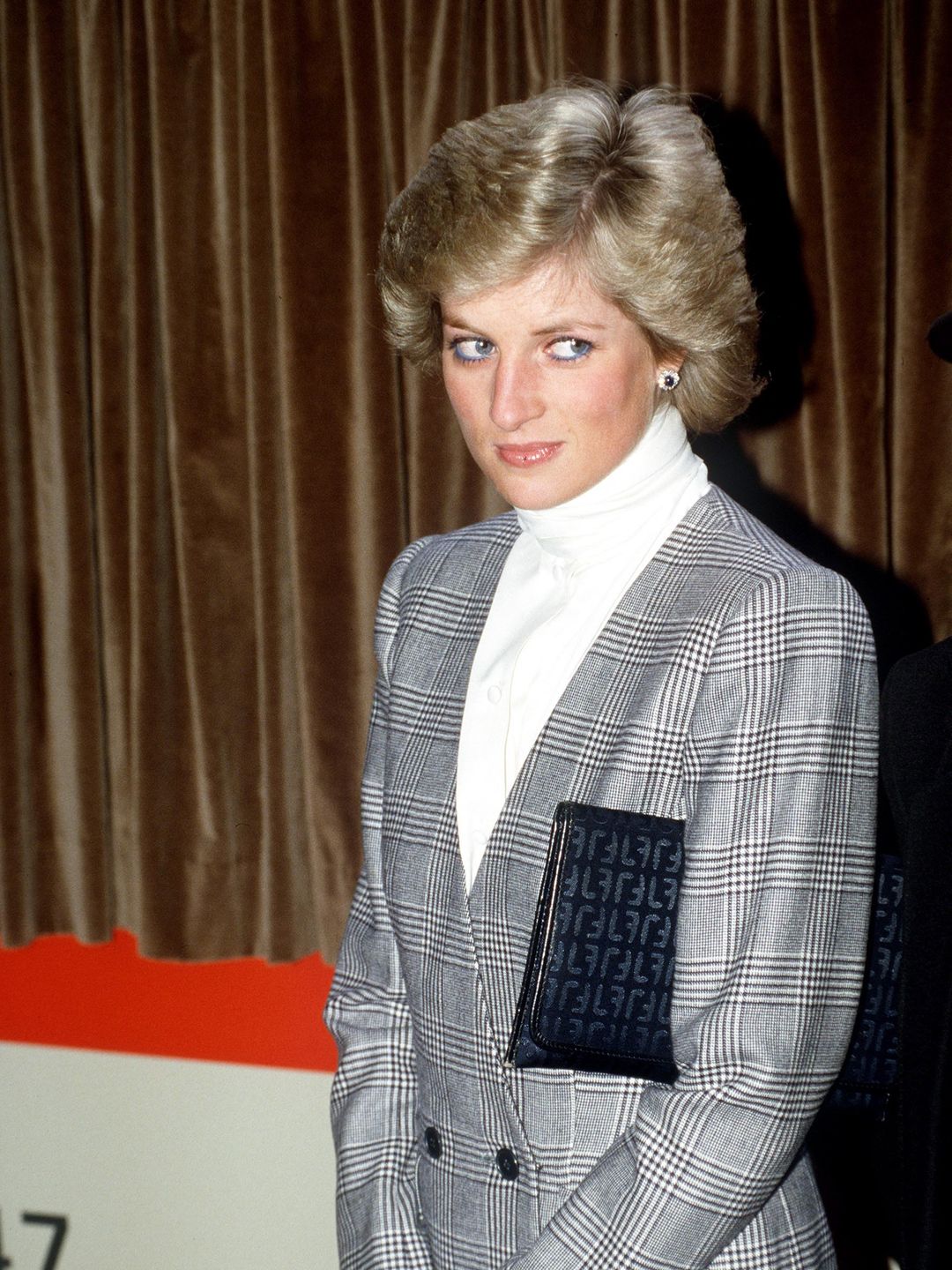 Princess Diana wears a grey blazer and white turtleneck at  Paddington Station, London