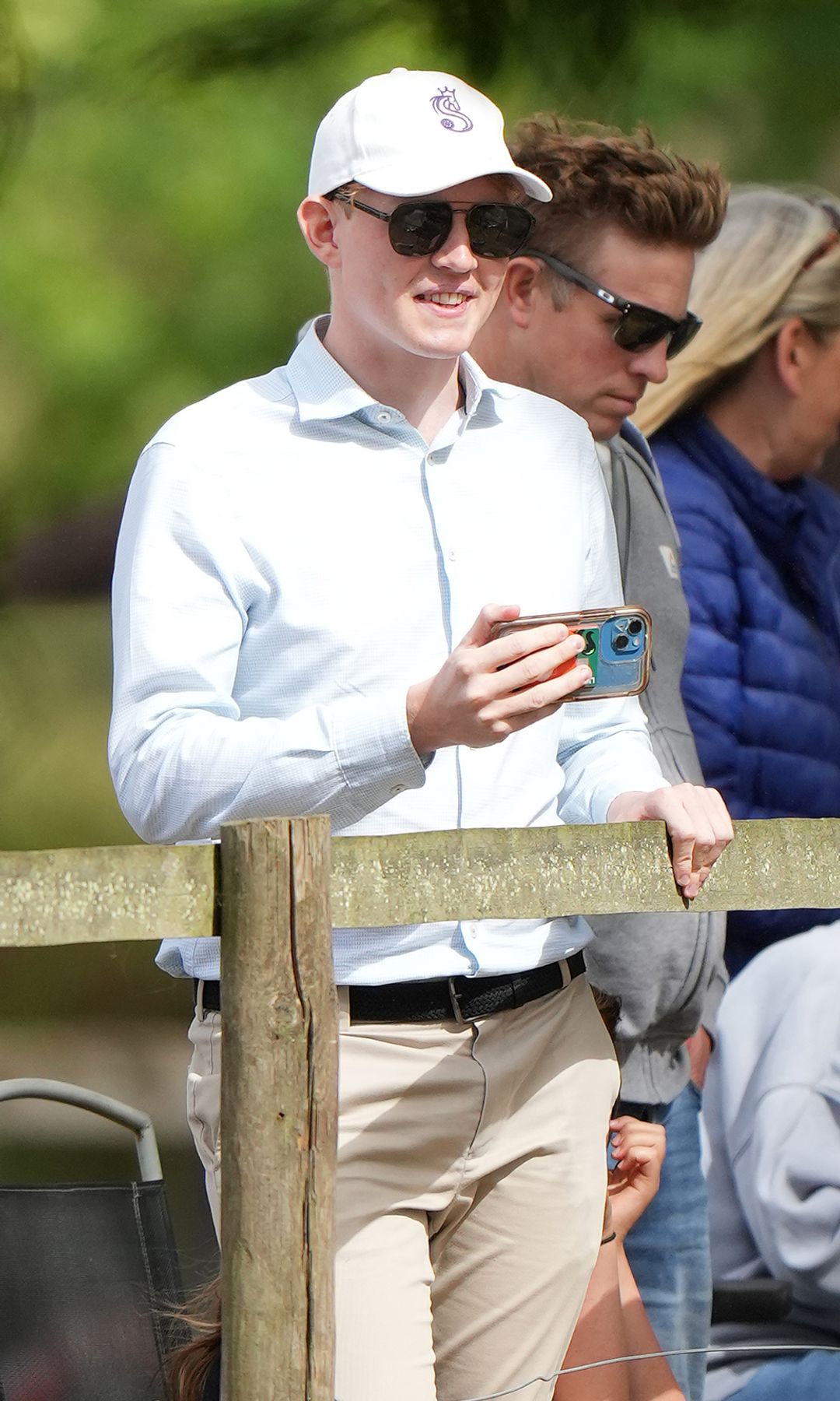 Felix da Silva-Clamp filming on his phone behind a fence