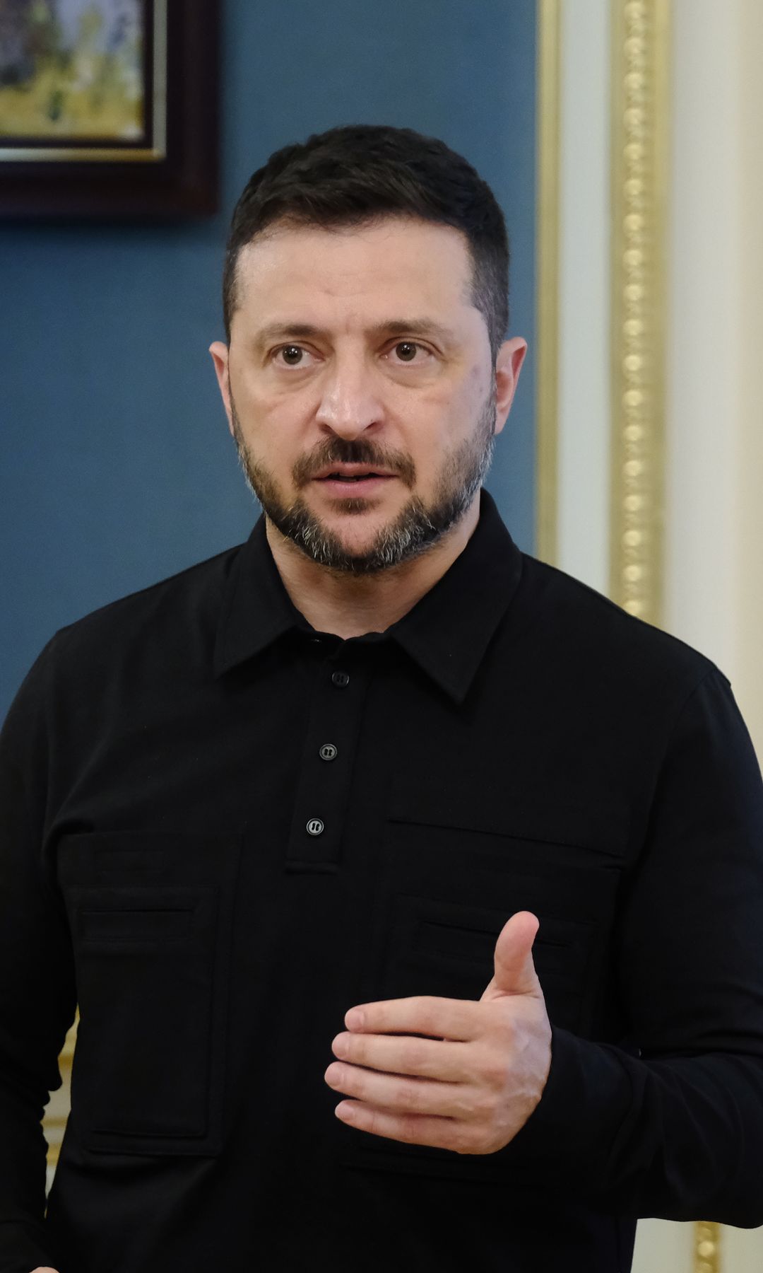 Volodymyr Zelenskyy speaking near a Ukrainian flag