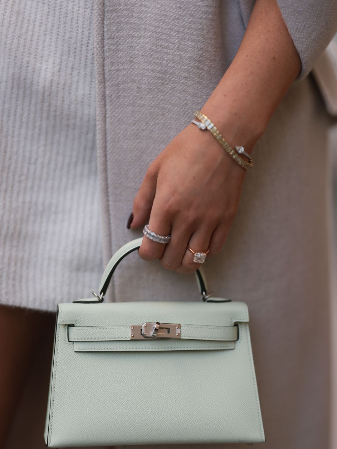 Leo Eberlin wearing Zara beige coat, H&M beige knit sweater dress, Hermes light green mini leather Kelly bag, Rolex gold Oyster Daydate watch and Leo Mathild jewelry on October 28, 2022 in Berlin, Germany. 