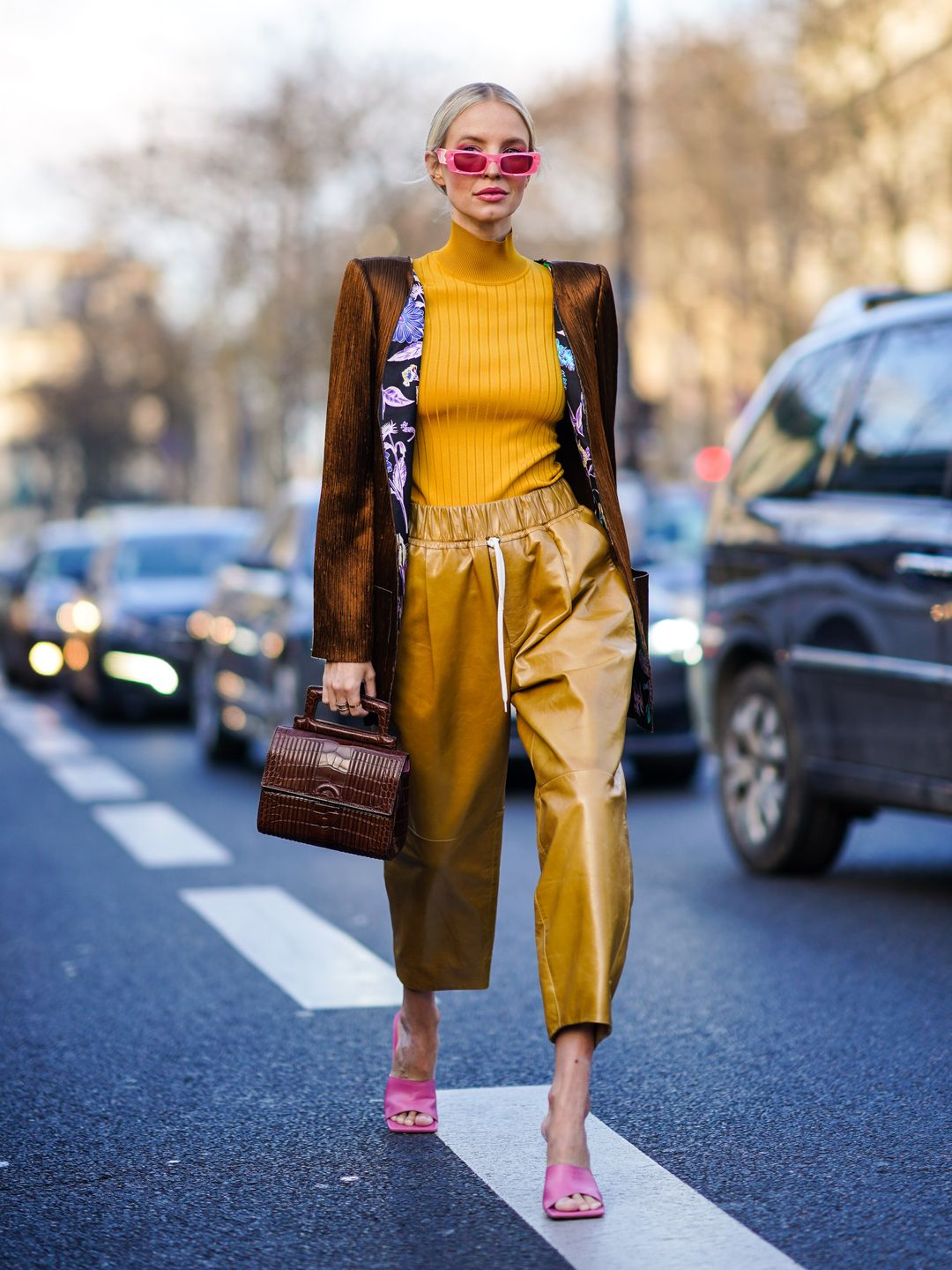 Leonie Hanne wears an orange turtleneck and cropped leather trousers 