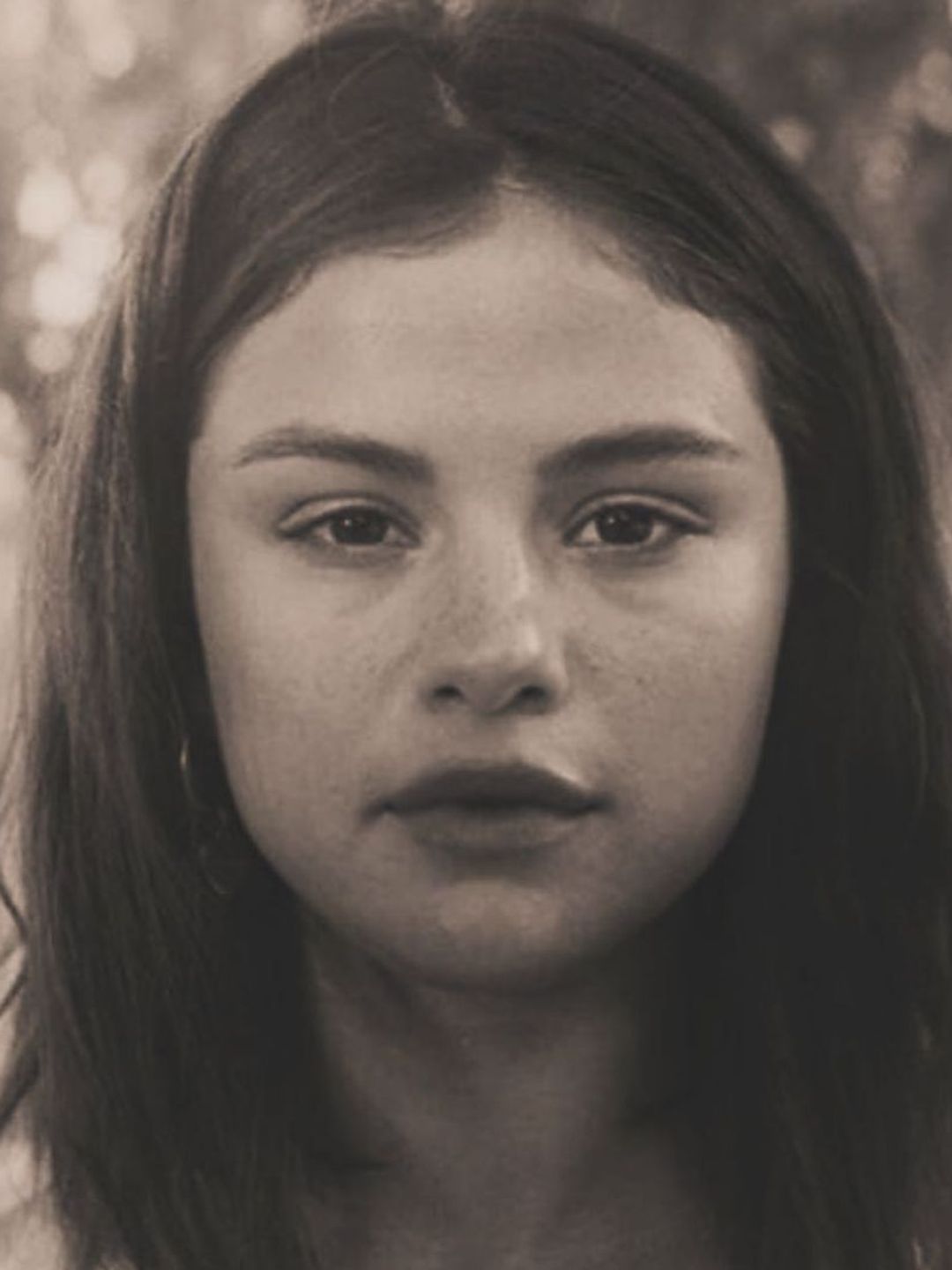 Black and white image of Selena Gomez with minimal-to-no makeup 