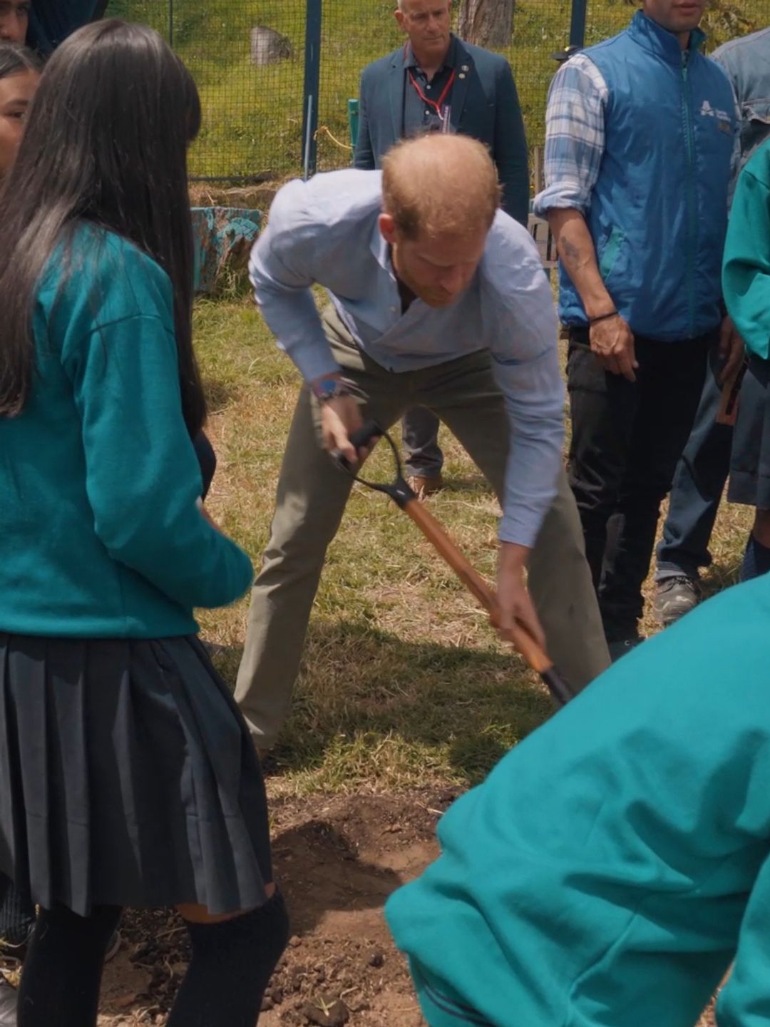 Prince Harry planting a tree with a group of students