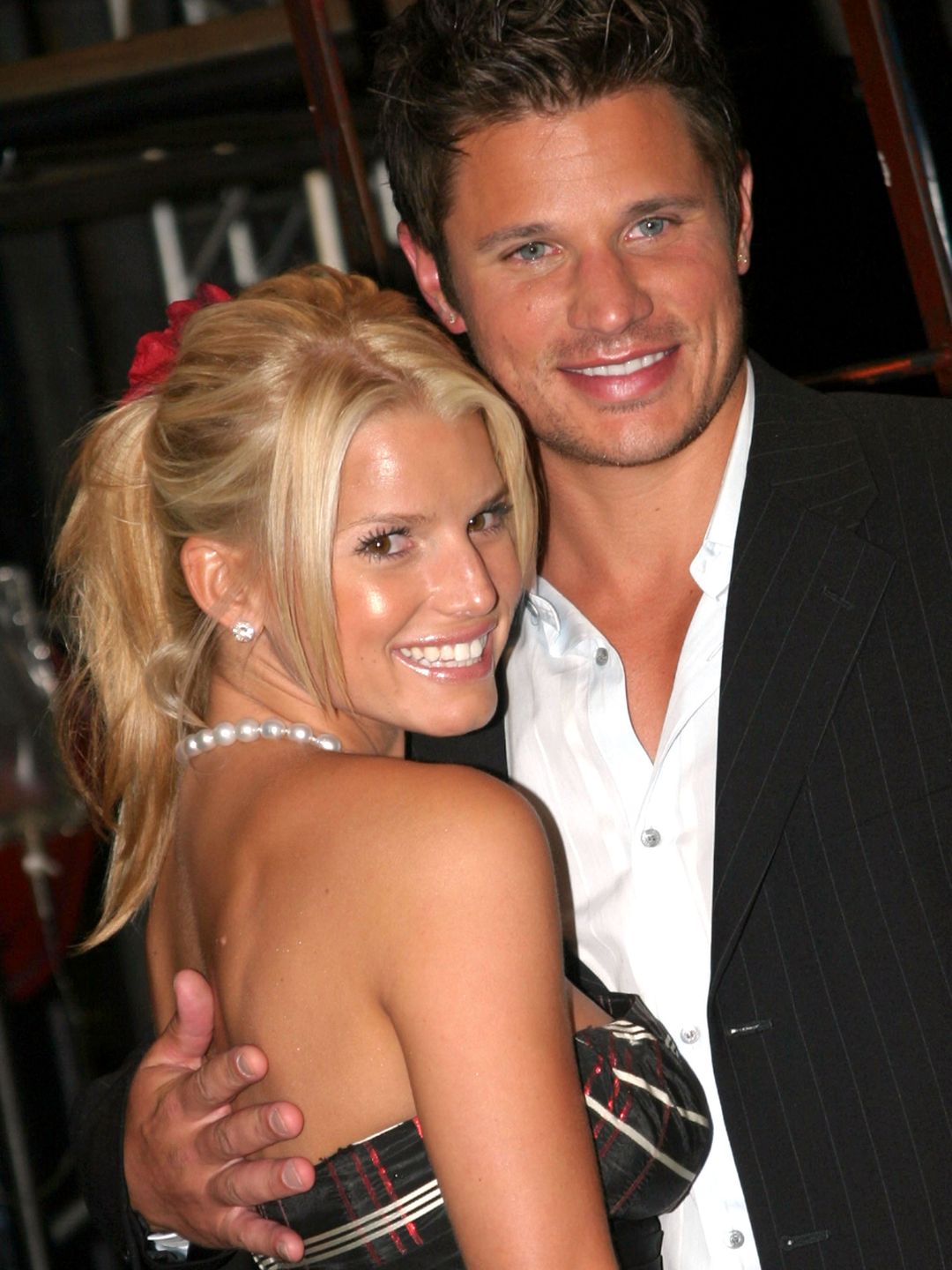 Jessica Simpson and Nick Lachey smiling together at an event