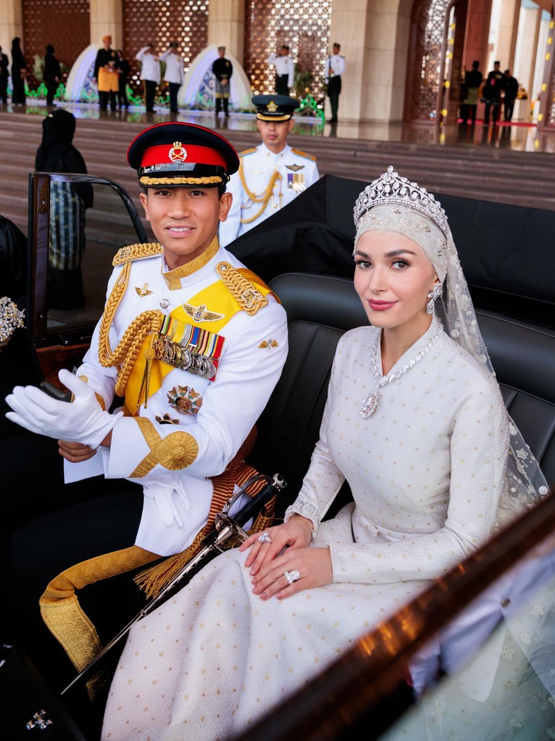 Princess Anisha and husband Prince Mateen pose in their wedding day outfits while in a carriage 