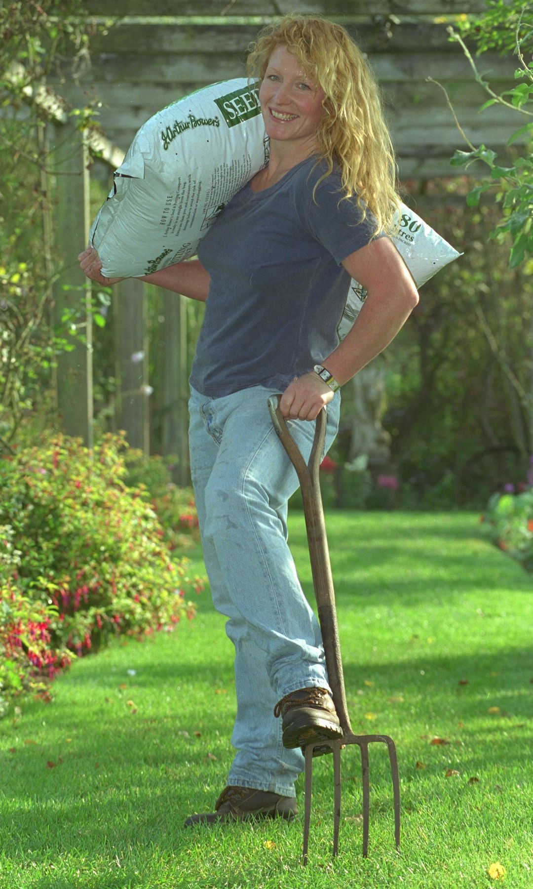 Charlie Dimmock with a pitchfork and bag of soil