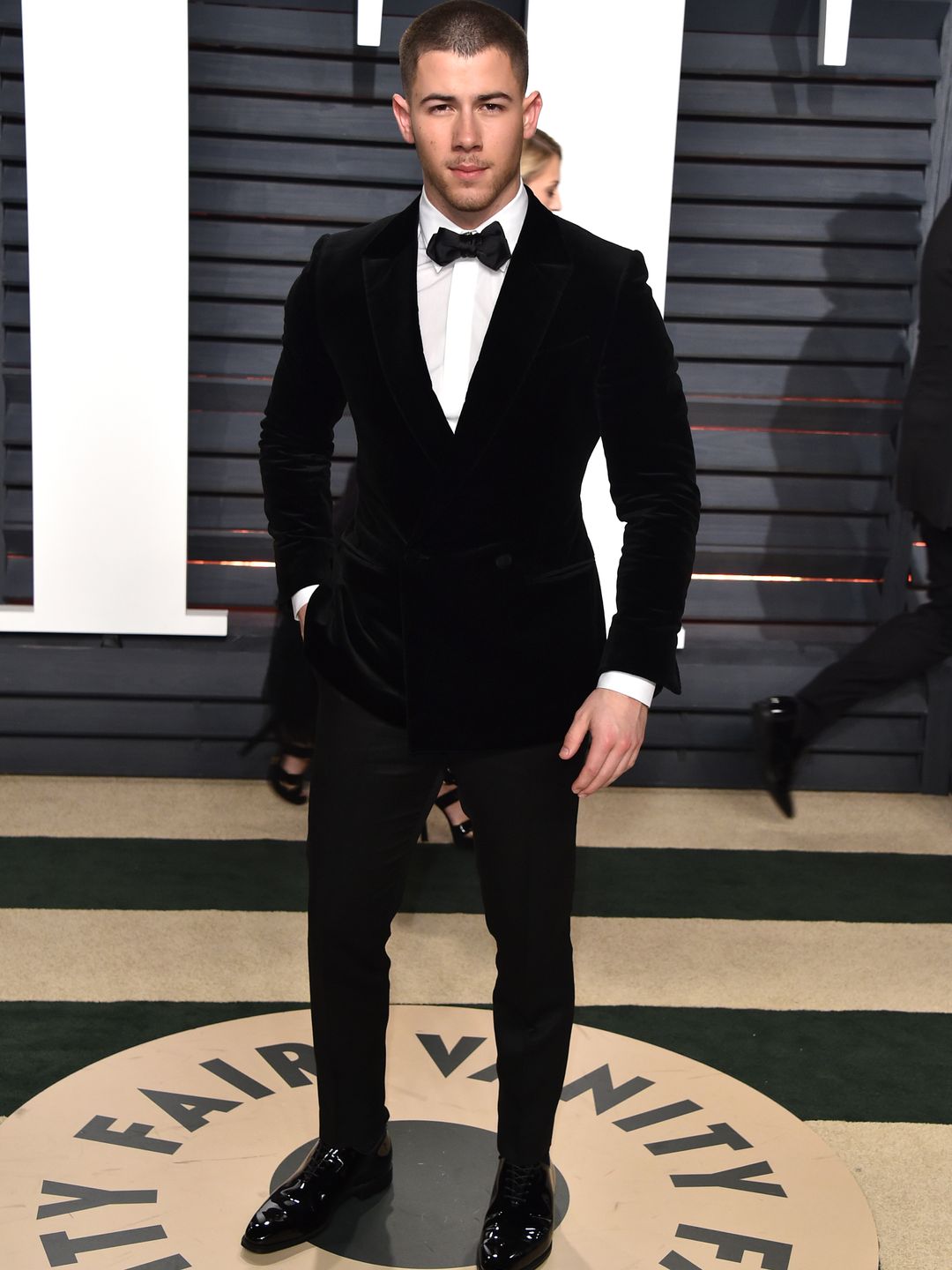 Nick stood in a suit at the Vanity Fair Oscars after party